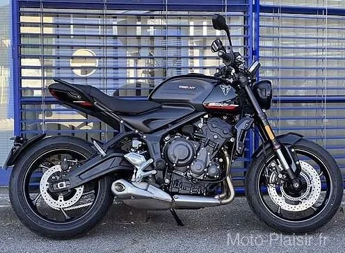 Black Yamaha motorcycle parked in front of a blue metal fence.