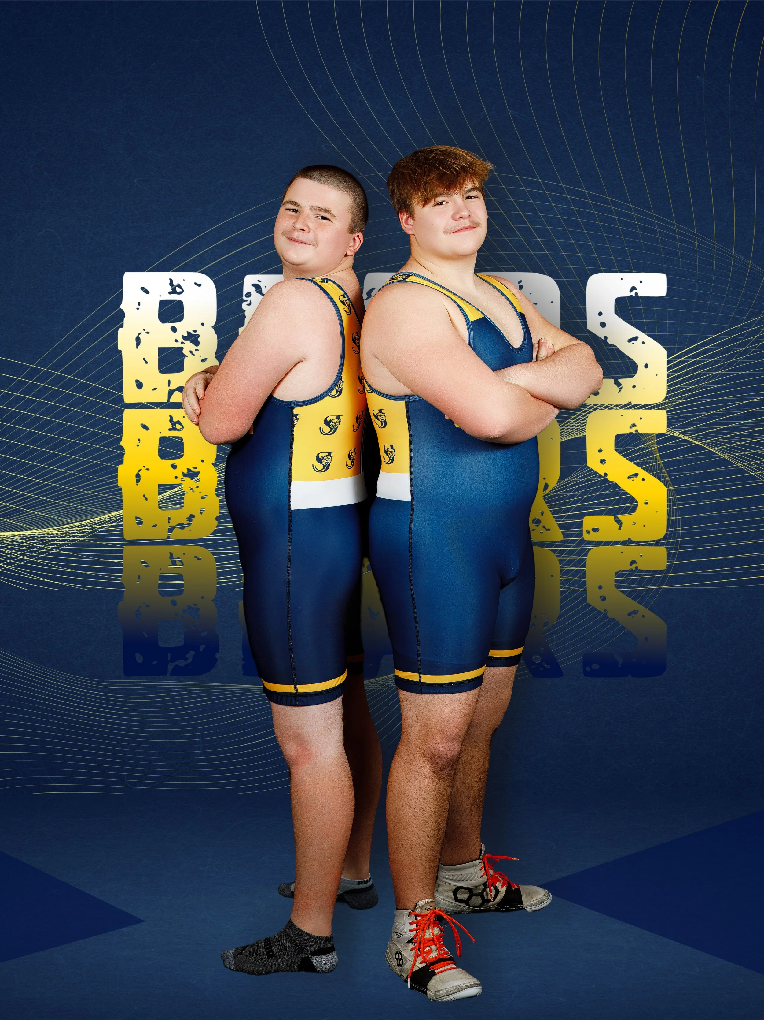 Two young male wrestlers in blue and yellow singlets standing back to back with arms crossed, in front of a blue background with the words 'BEARS' and 'BASKETBALL' in large yellow and white letters.