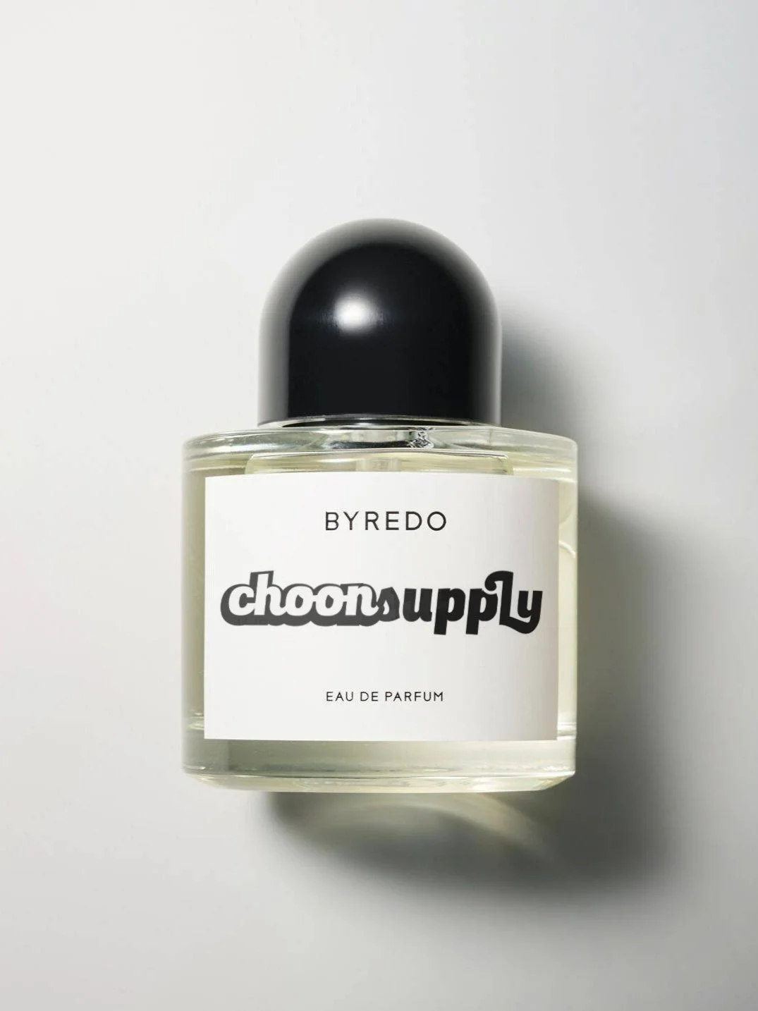A clear glass perfume bottle with a black rounded cap, labeled 'BYREDO Choonsupply Eau de Parfum' on a white background.