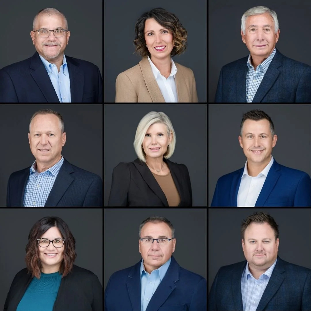 Grid of nine professional headshots of men and women in business attire against a dark gray background.