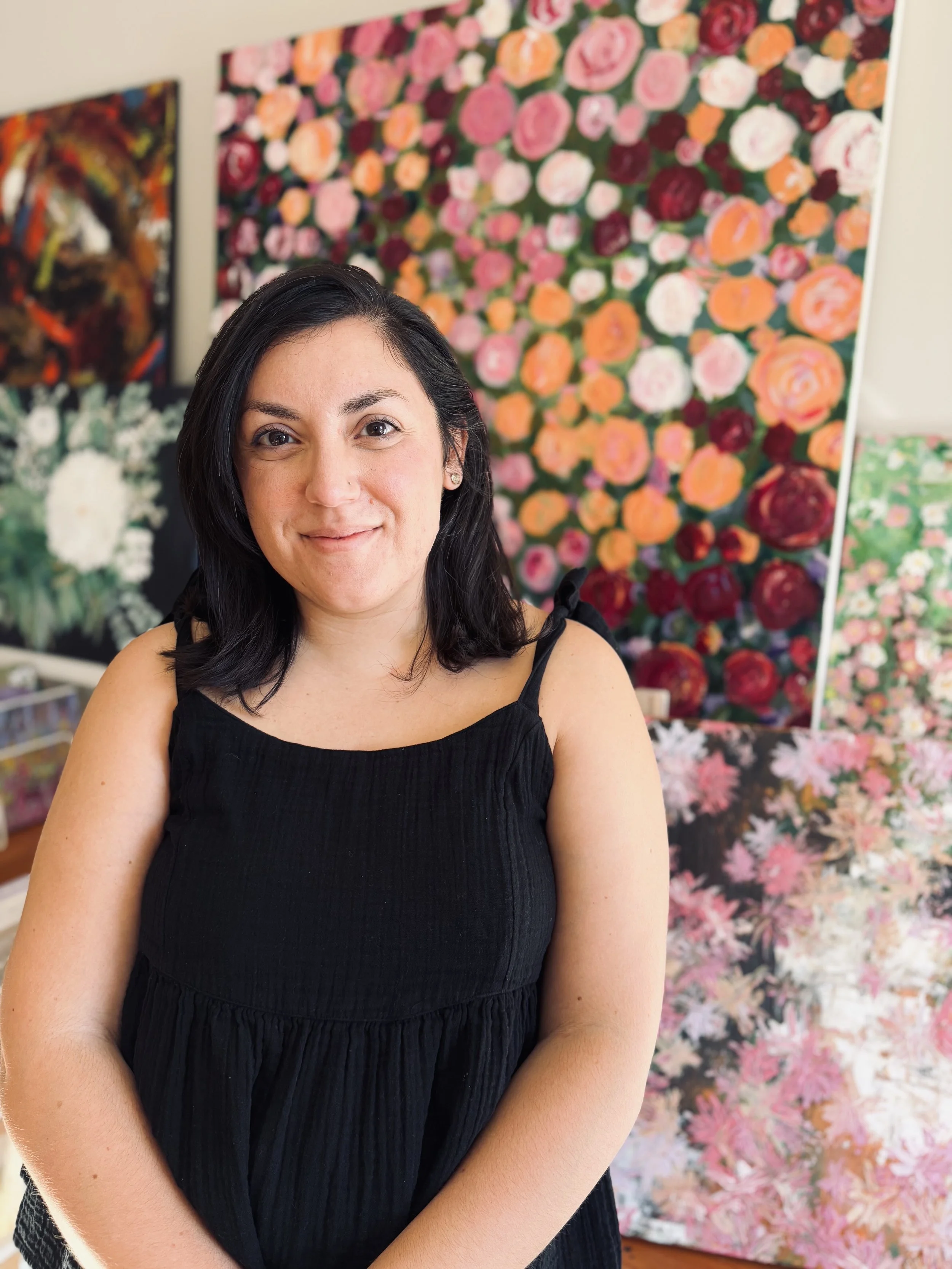 Maryland-based abstract artist Sahar Boussard standing in front of her paintings