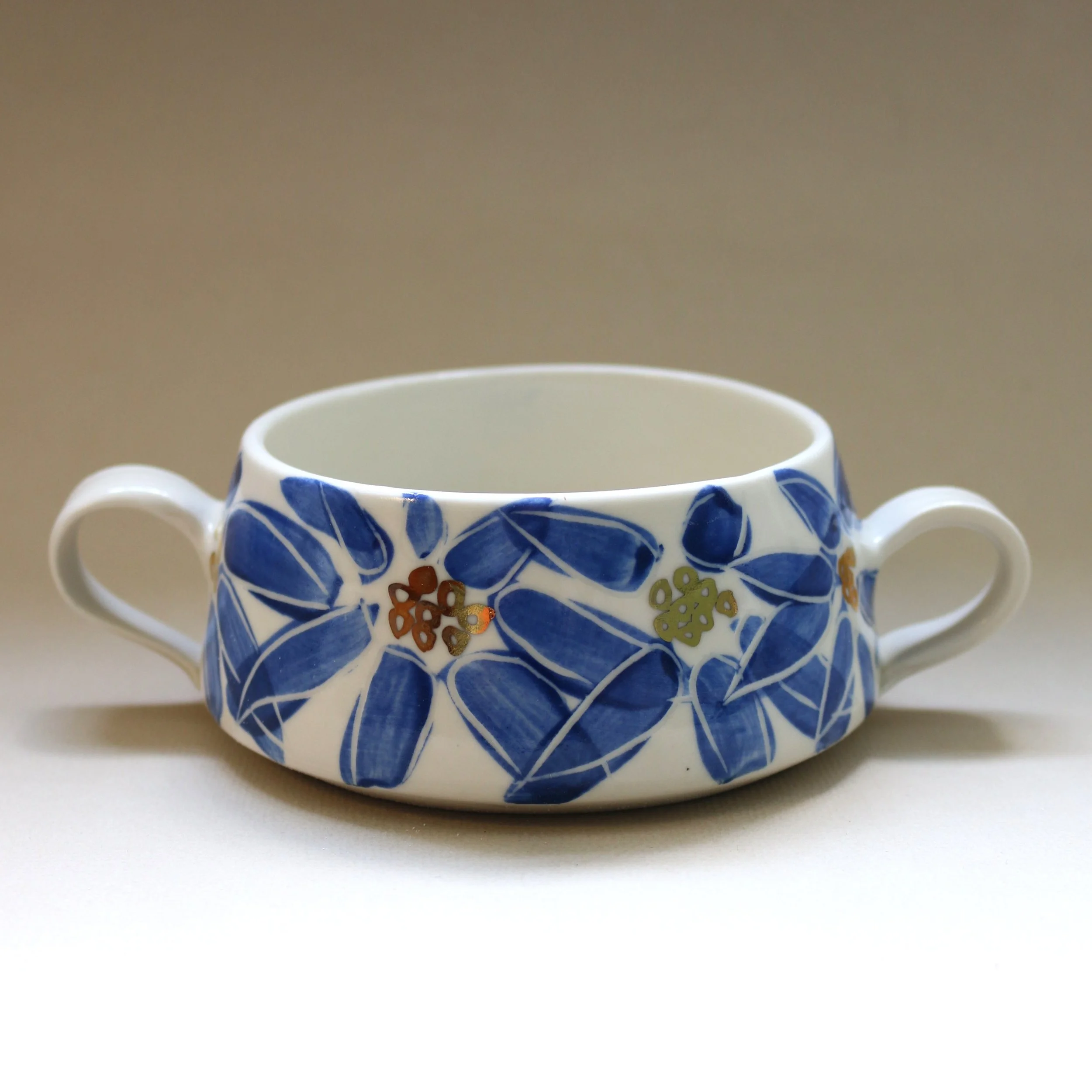 A white mug with a blue floral pattern on a white surface.