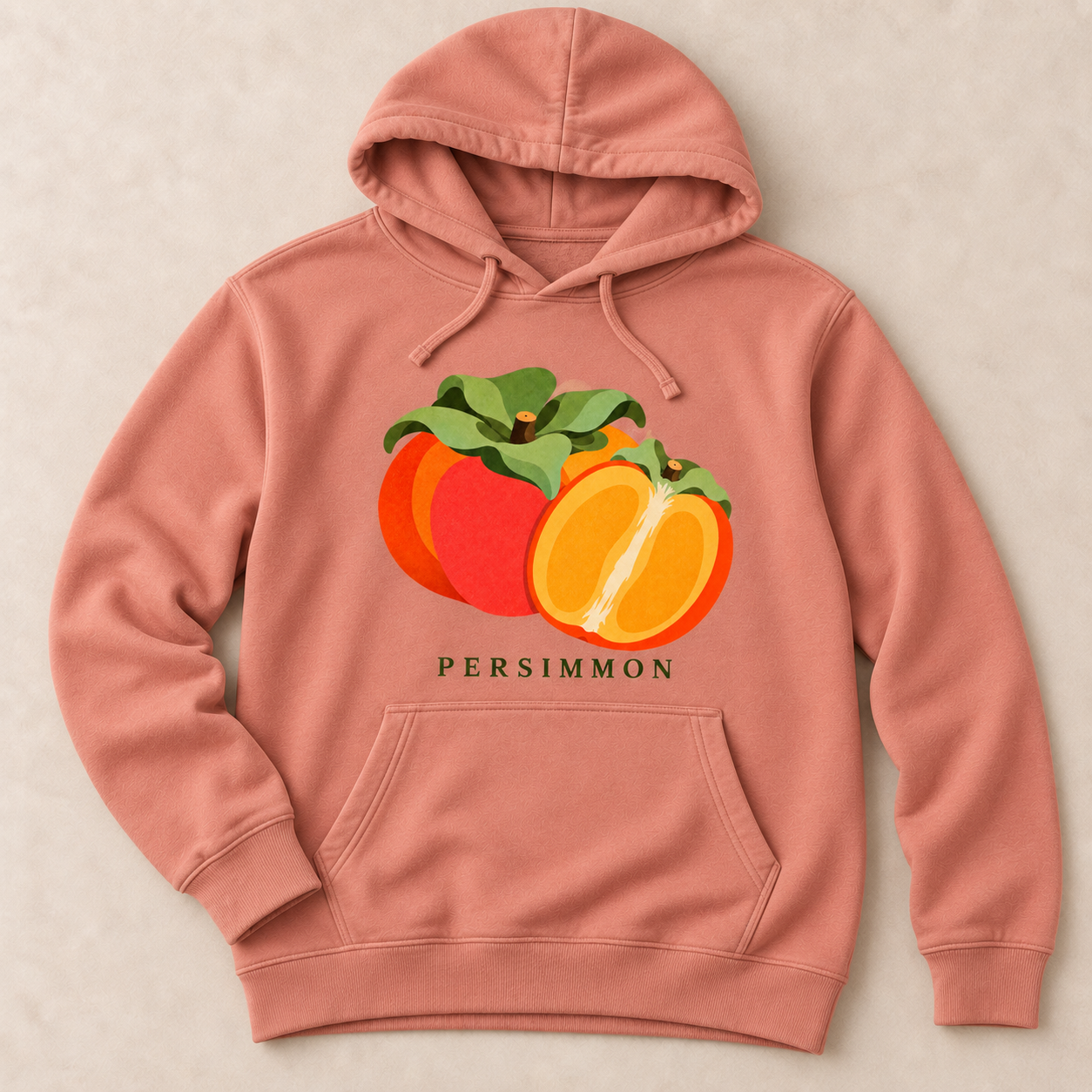 Dusty Rose Persimmon pullover hoodie with a whole orange persimmon, a cut half and green leaves above the front pocket.