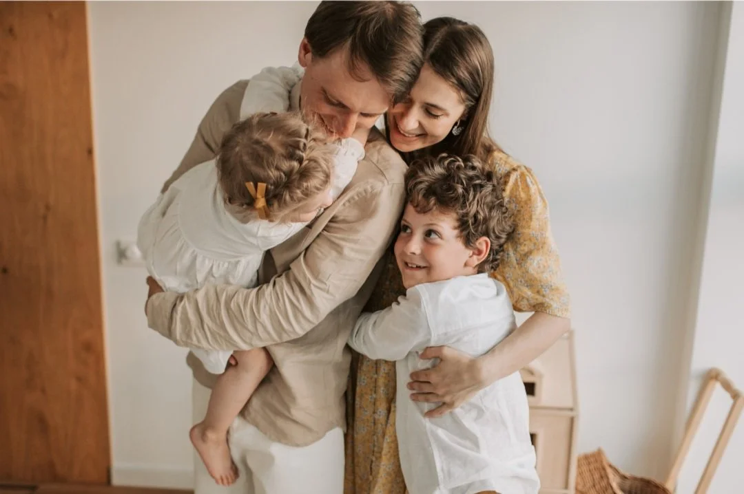 Parents showing affection and love to each other in front of their children, modeling a healthy marriage.