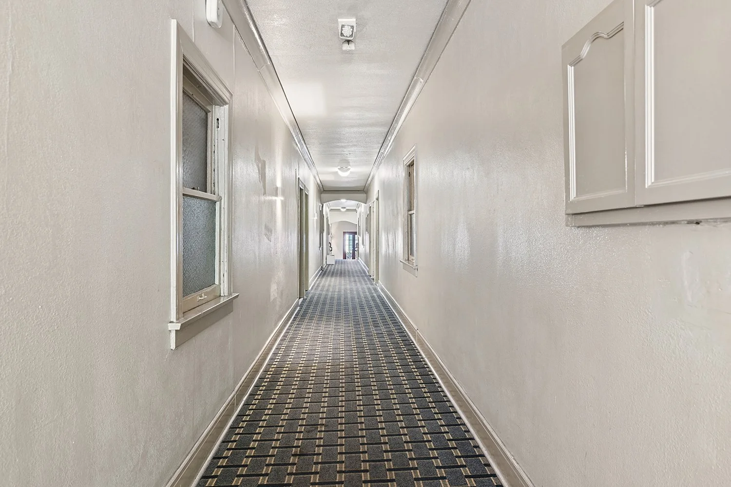 Hallway at Cahuenga Apartments with cool carpet and charming architectural details. 