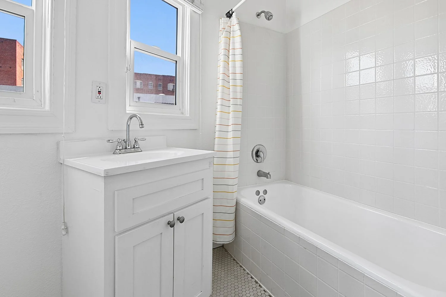 Bathroom in Cahuenga Apartment home with a shower/tub and windows allowing for gorgeous natural lighting. 