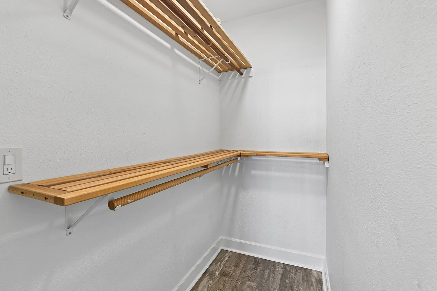 Spacious closet in Cahuenga Apartment home with wood flooring and built-in shelving for optimal use of storage space. 