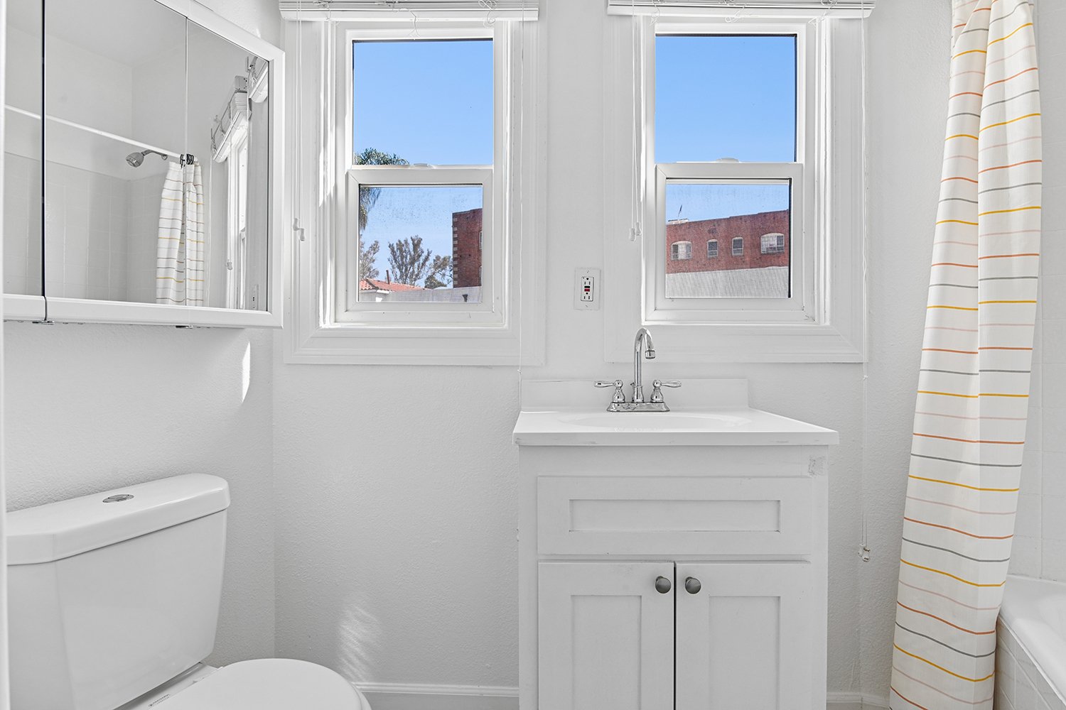 Bathroom in Cahuenga Apartment home with a shower/tub and windows allowing for gorgeous natural lighting. 