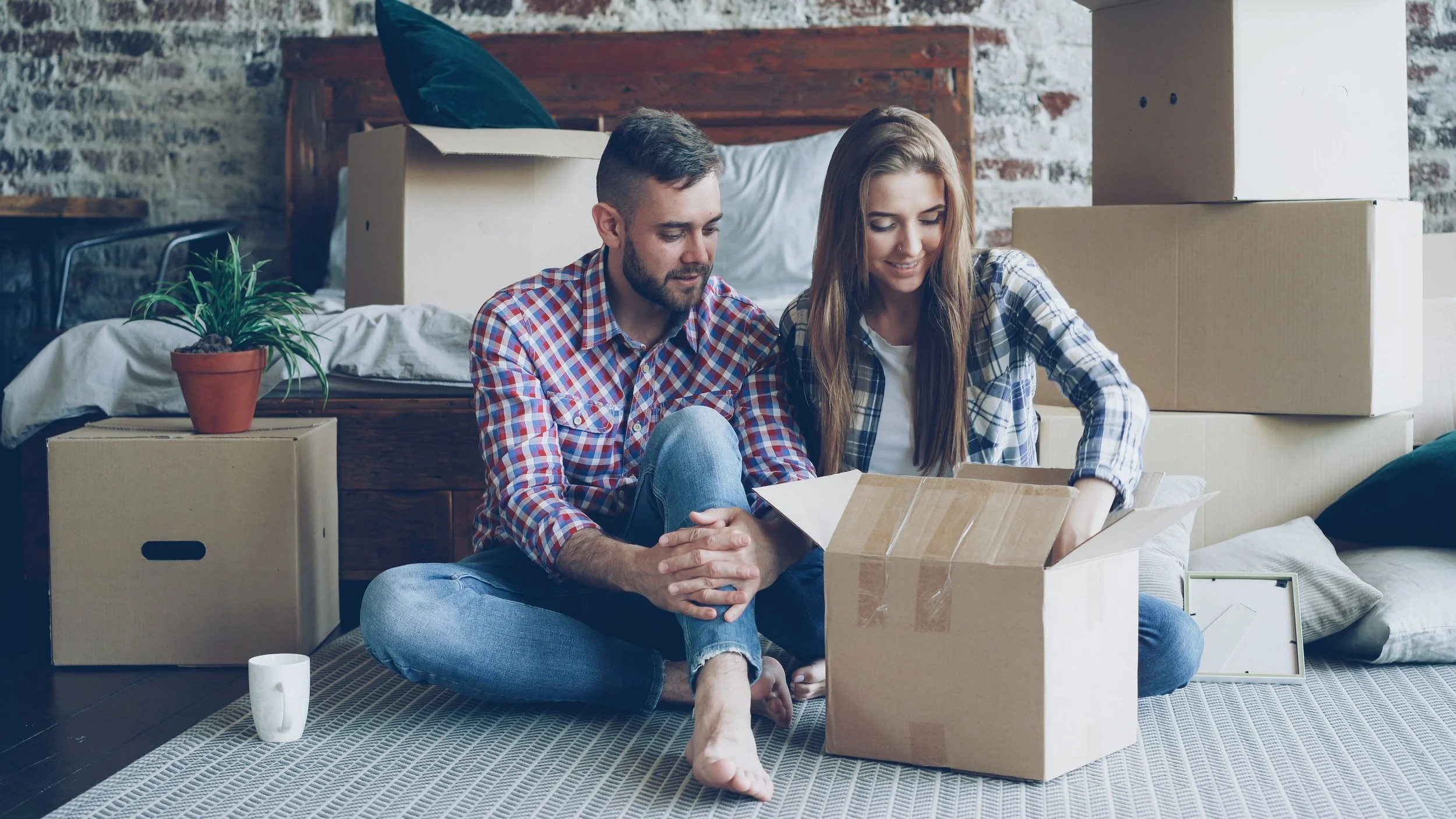 Couple packing their apartment while considering whether to sell or rent their NYC home.