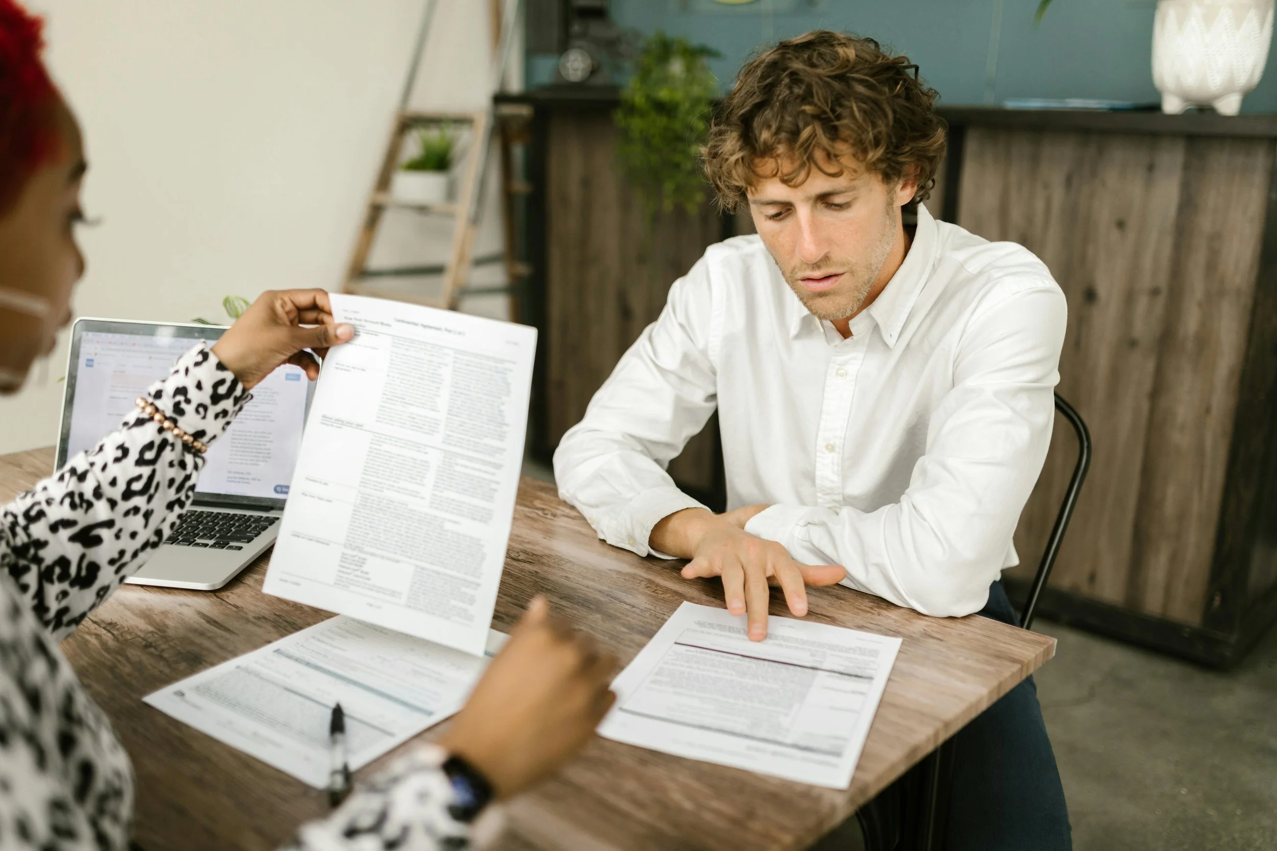 NYC home buyer reviewing real estate transaction documents with agent at table