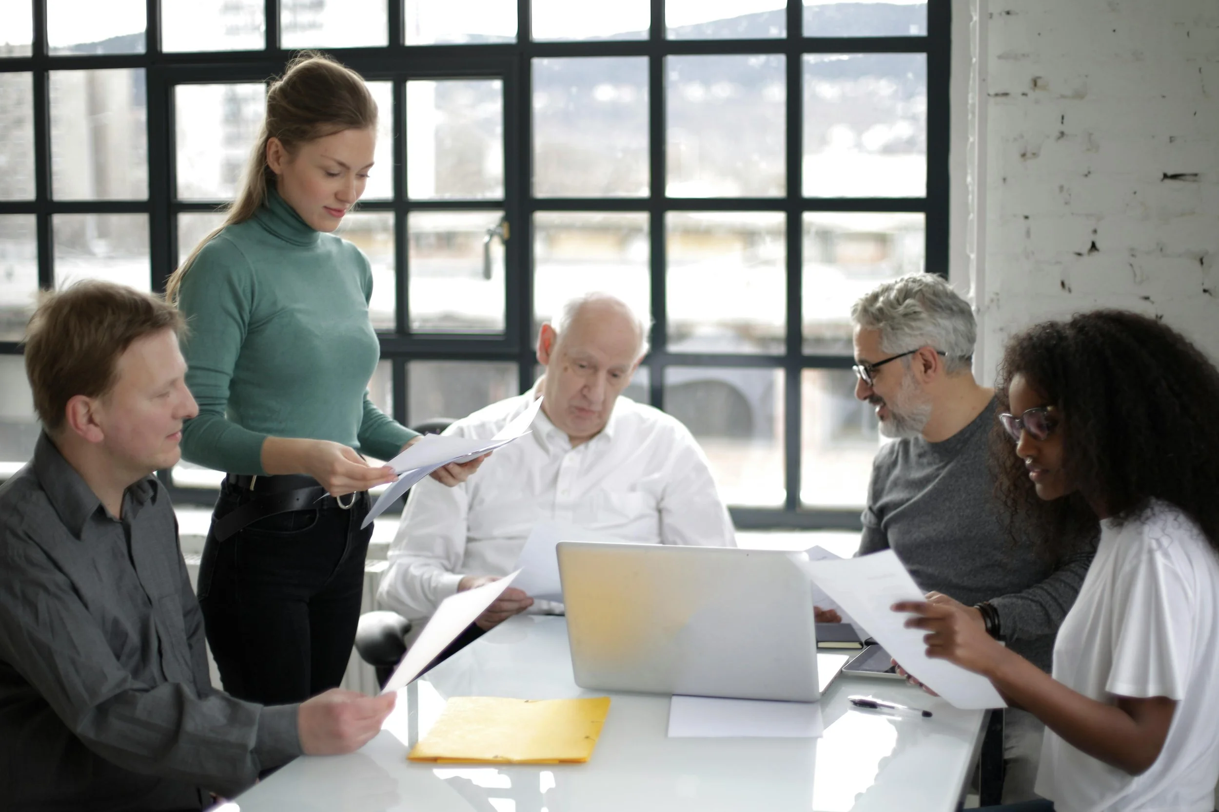 Co-op board members and building representatives reviewing financial documents during a residential building meeting in New York City.