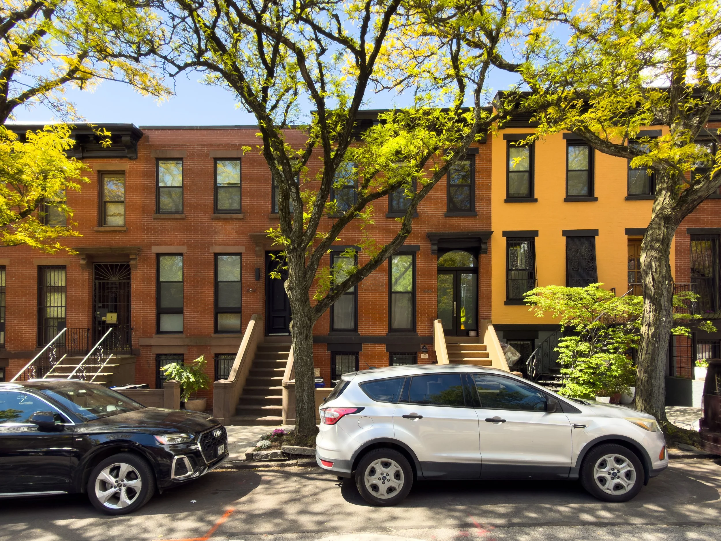 Tree-lined row of brick townhouses in Gowanus, Brooklyn, NYC, highlighting the neighborhood’s low-rise residential streetscape and real estate character.
