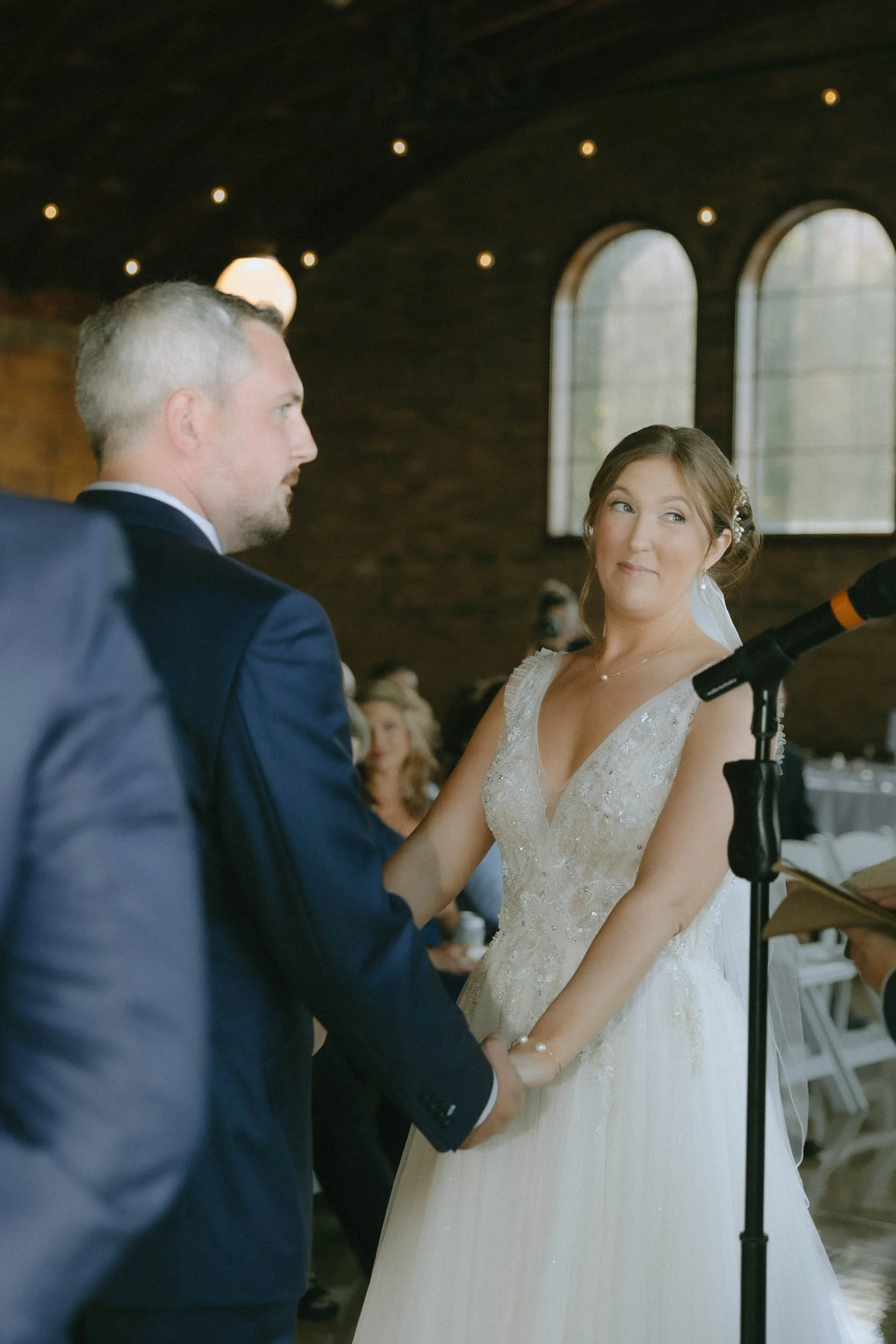Couple getting married in an antique building. Bride smiling at officiant.