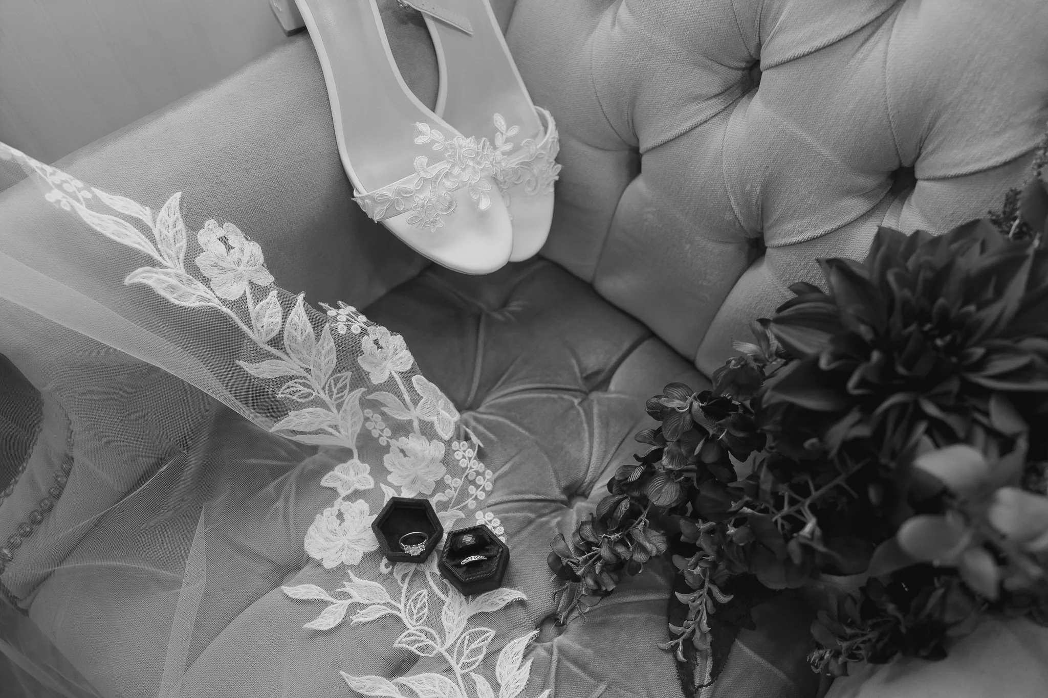 detail shot of wedding rings, veil, and bouquet