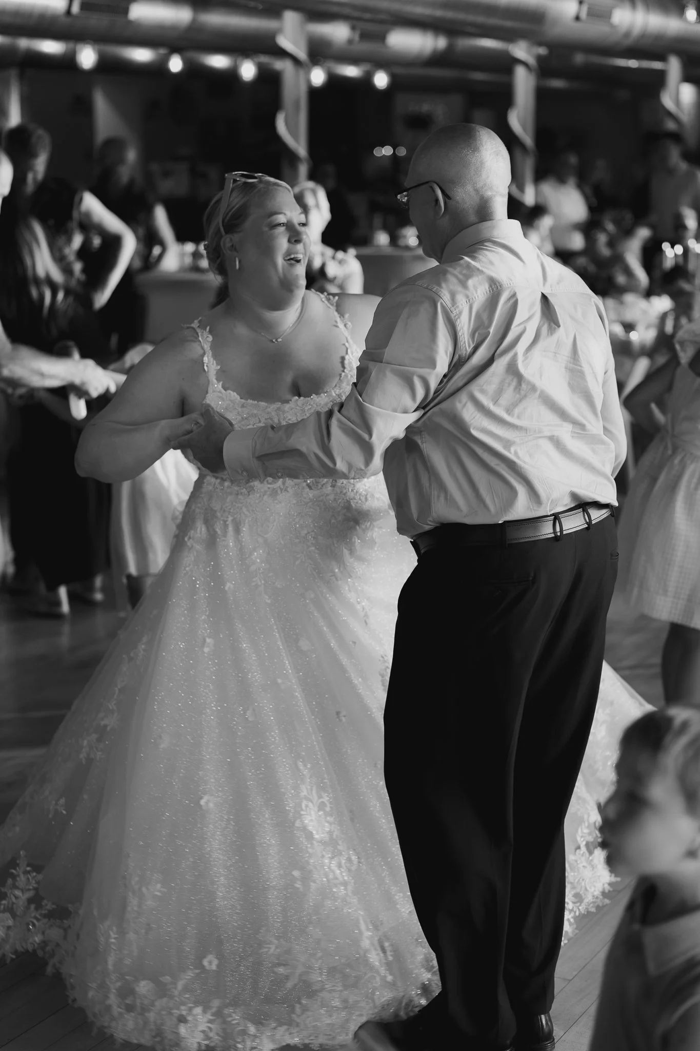 bride dancing with grandfather as her dress swirls around catching smiles and sparkle