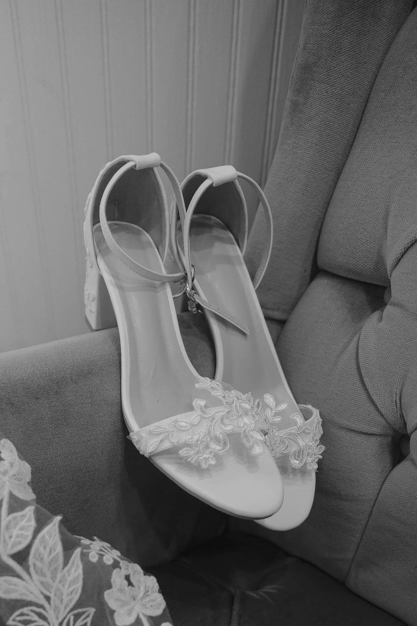 detail of wedding shoes resting on a vintage chair in black and white