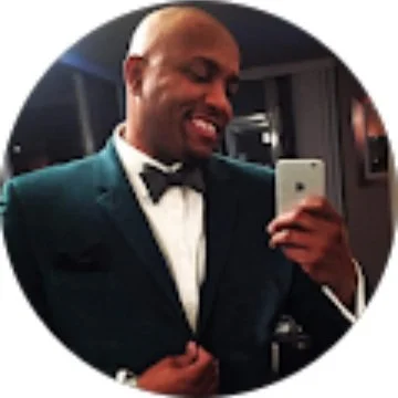Man in a suit taking a selfie in a mirror