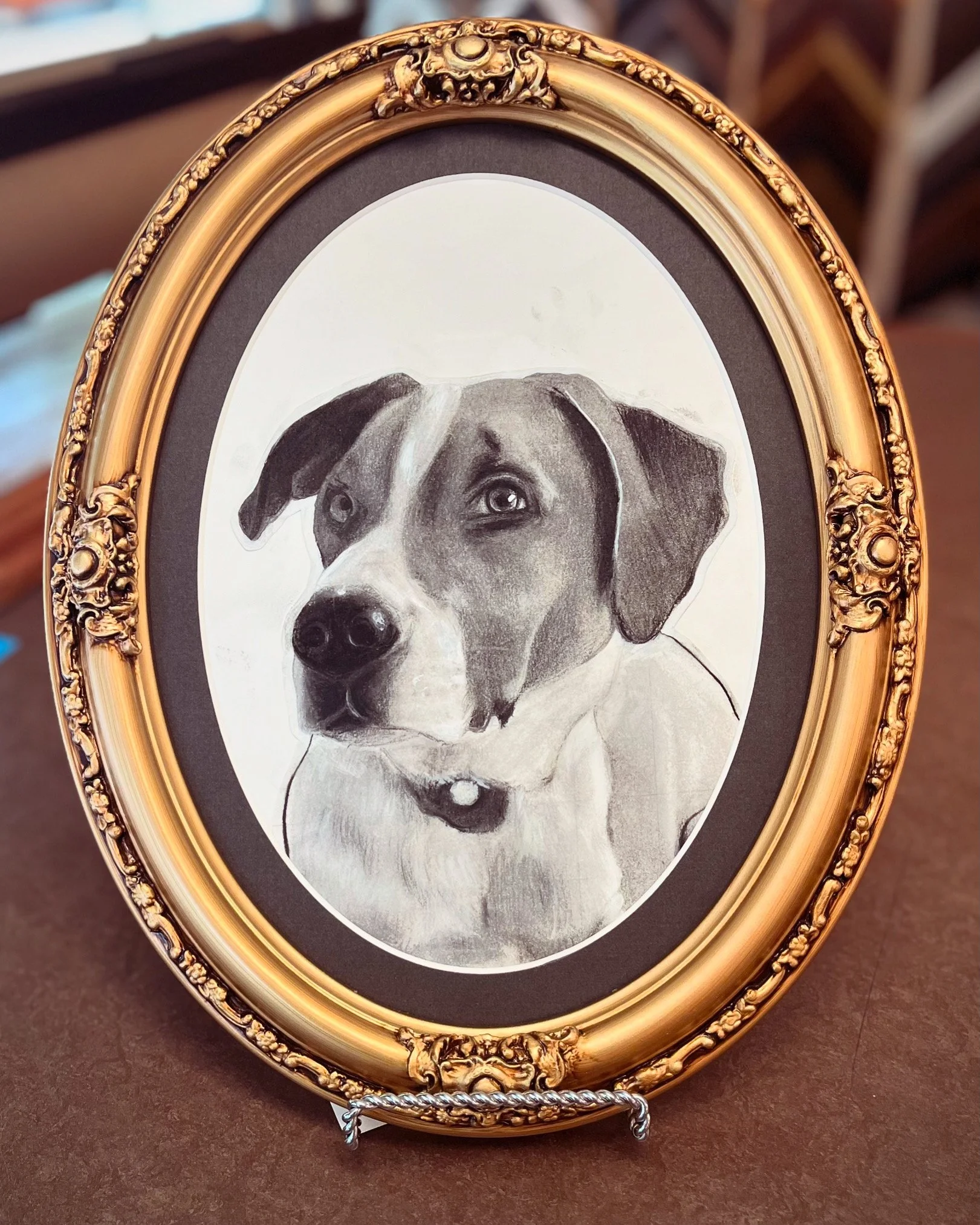Sketch of a dog in a gold oval frame