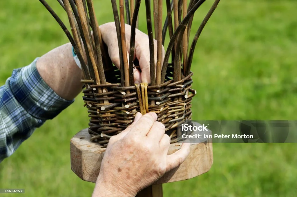 Close-up image of a man weaving a basket. Experiencing a traditional craft is one of the best ways to support regenerative travel.