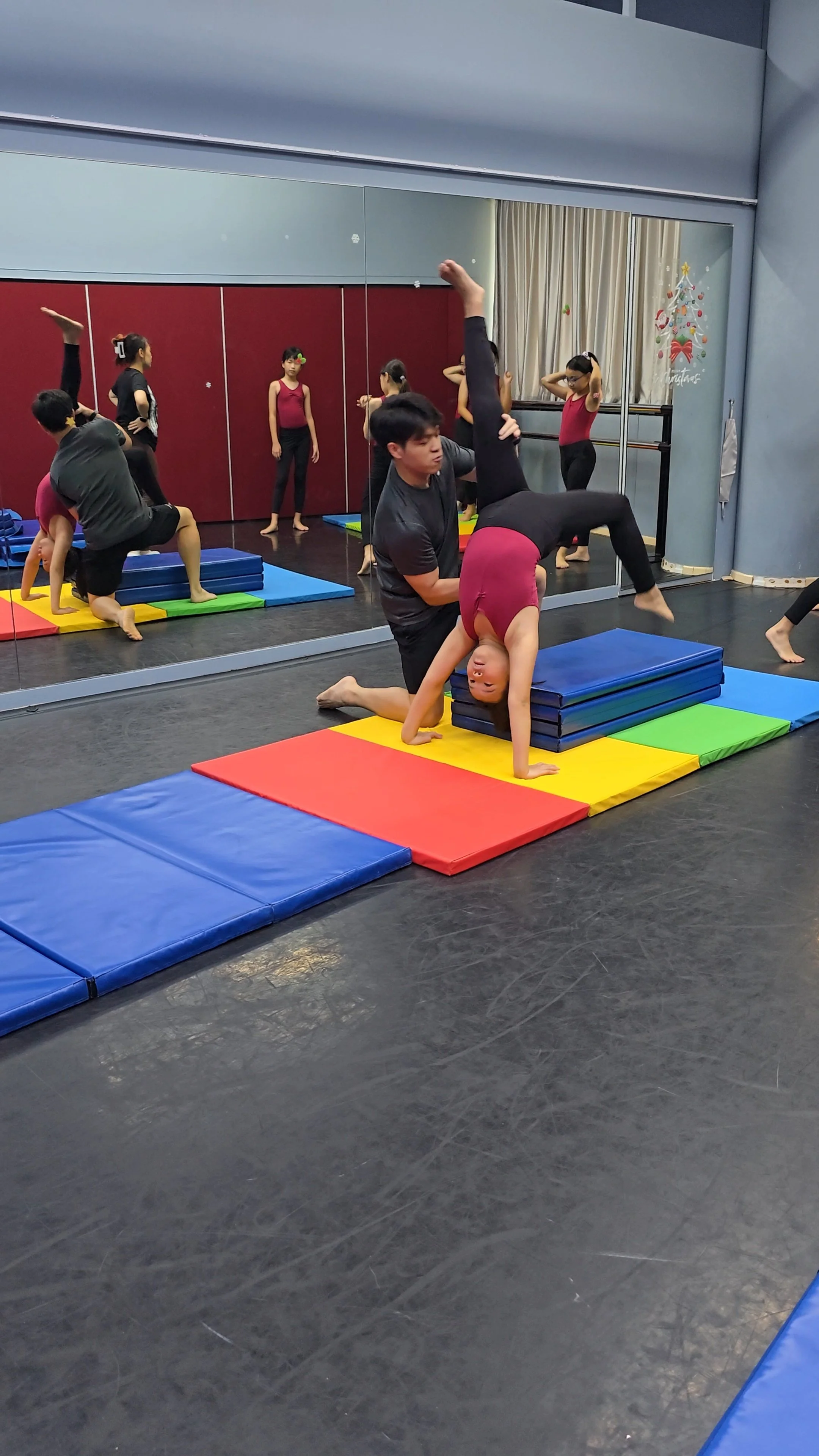 coach assisting a student to a backward flip