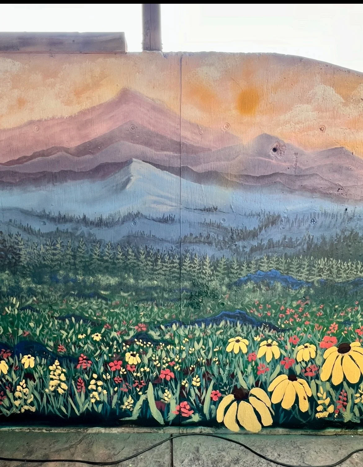 Mural depicting mountains, forest, and wildflowers