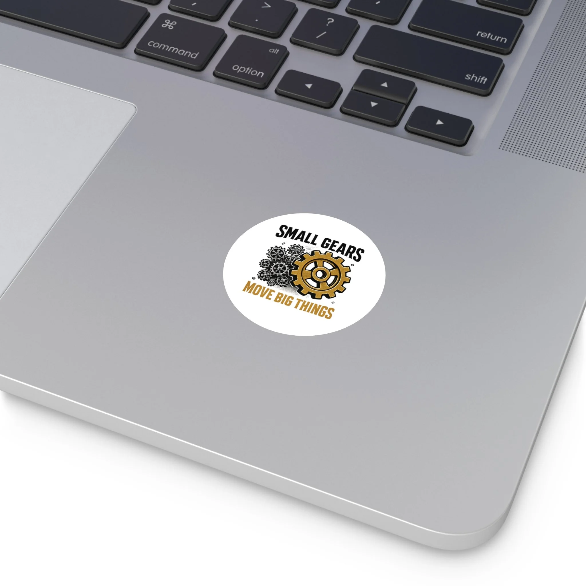 Round matte vinyl sticker with black gear cluster and one bronze gear reading “SMALL GEARS — MOVE BIG THINGS.