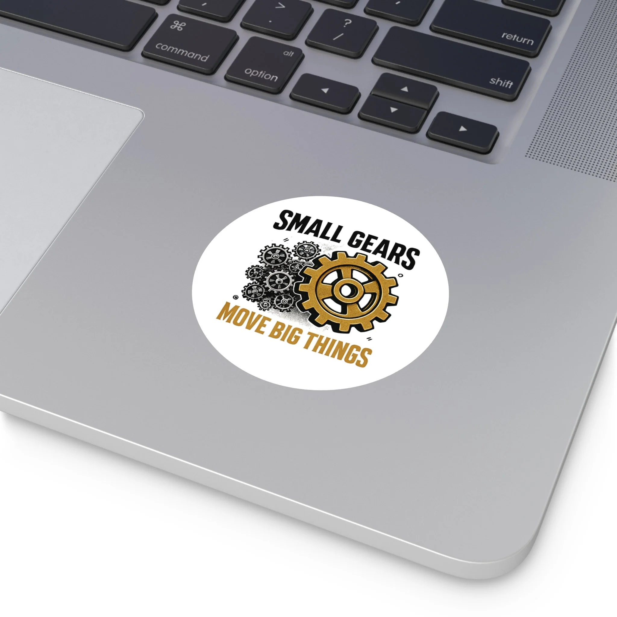 Round matte vinyl sticker with black gear cluster and one bronze gear reading “SMALL GEARS — MOVE BIG THINGS.