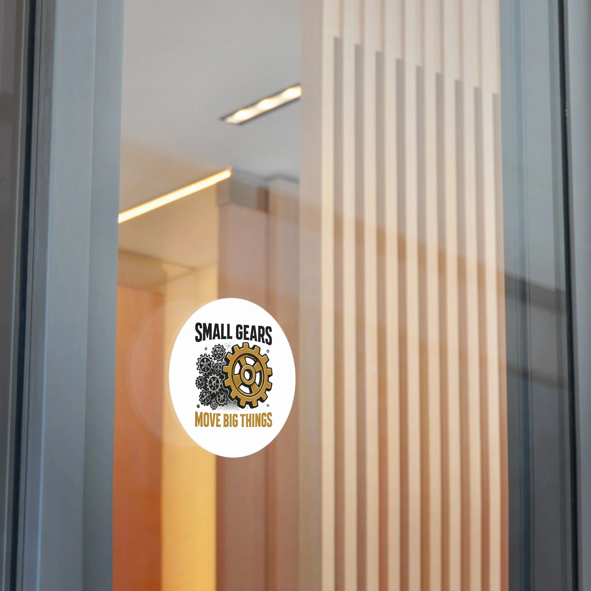 Round matte vinyl sticker with black gear cluster and one bronze gear reading “SMALL GEARS — MOVE BIG THINGS.