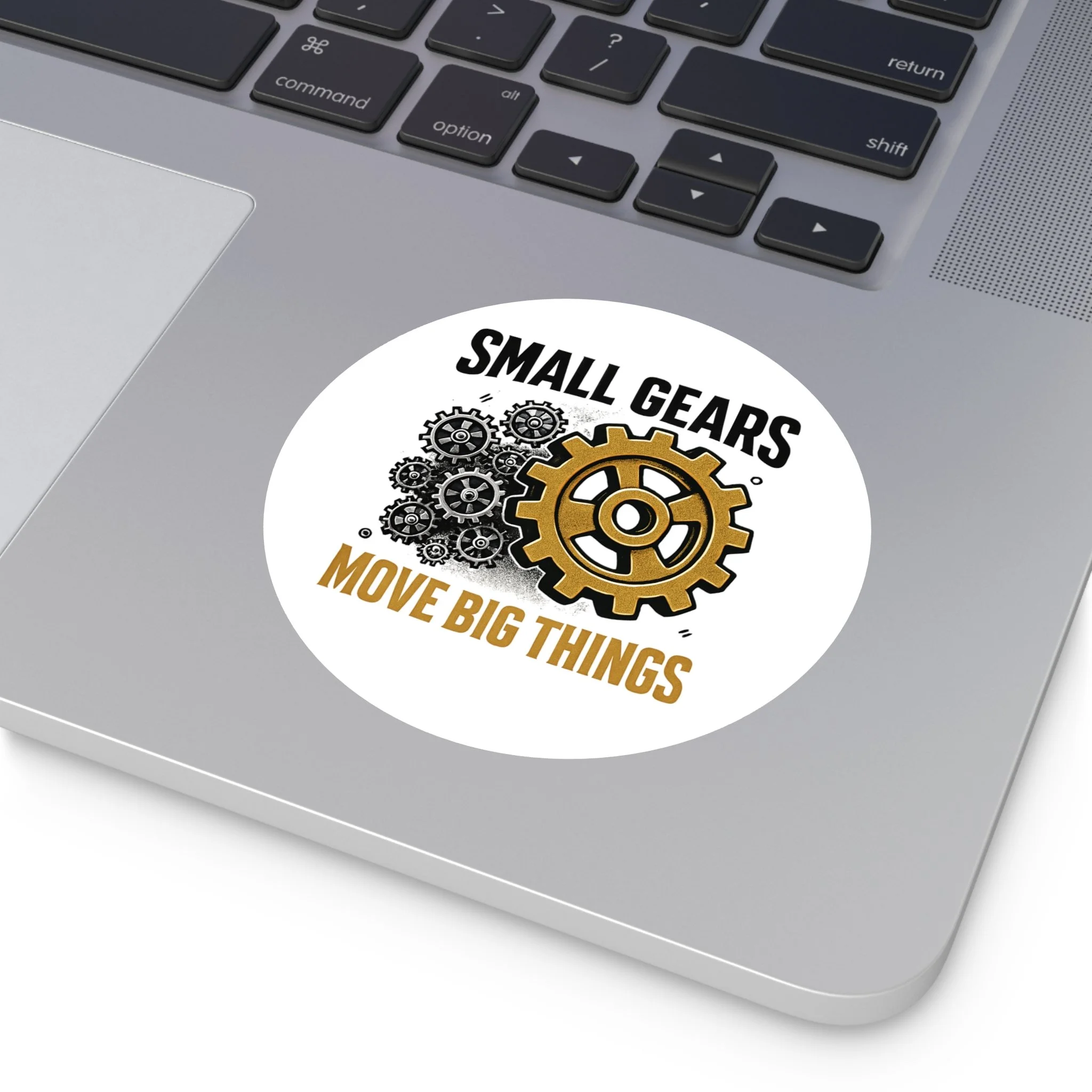 Round matte vinyl sticker with black gear cluster and one bronze gear reading “SMALL GEARS — MOVE BIG THINGS.