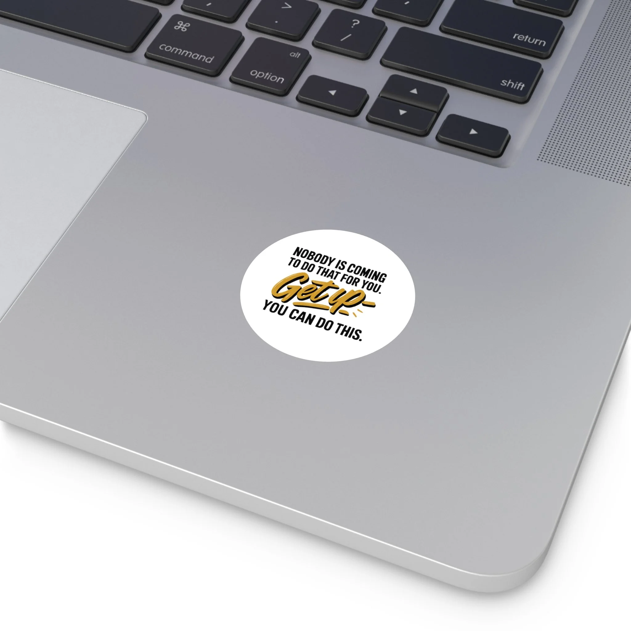 Round matte vinyl sticker with hand-lettered gold “Get up” and bold black type, motivational design for laptops and water bottles.
