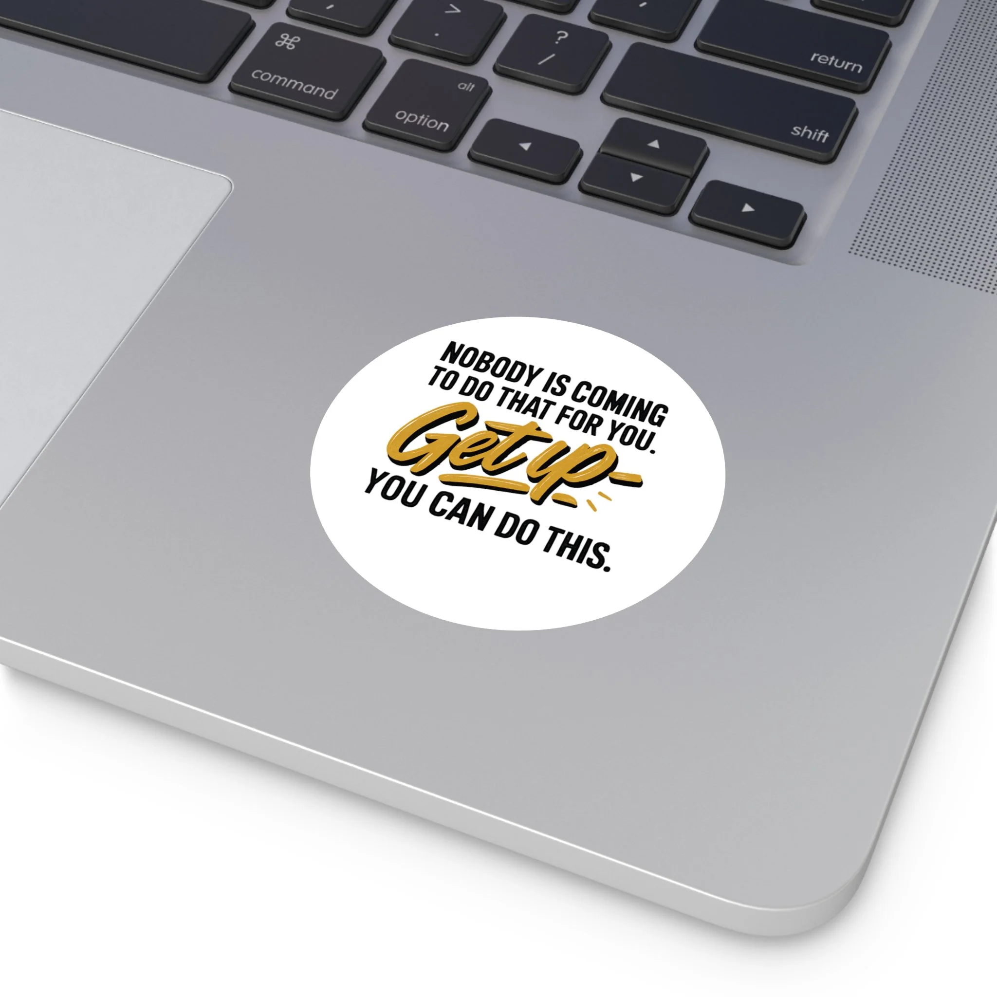 Round matte vinyl sticker with hand-lettered gold “Get up” and bold black type, motivational design for laptops and water bottles.