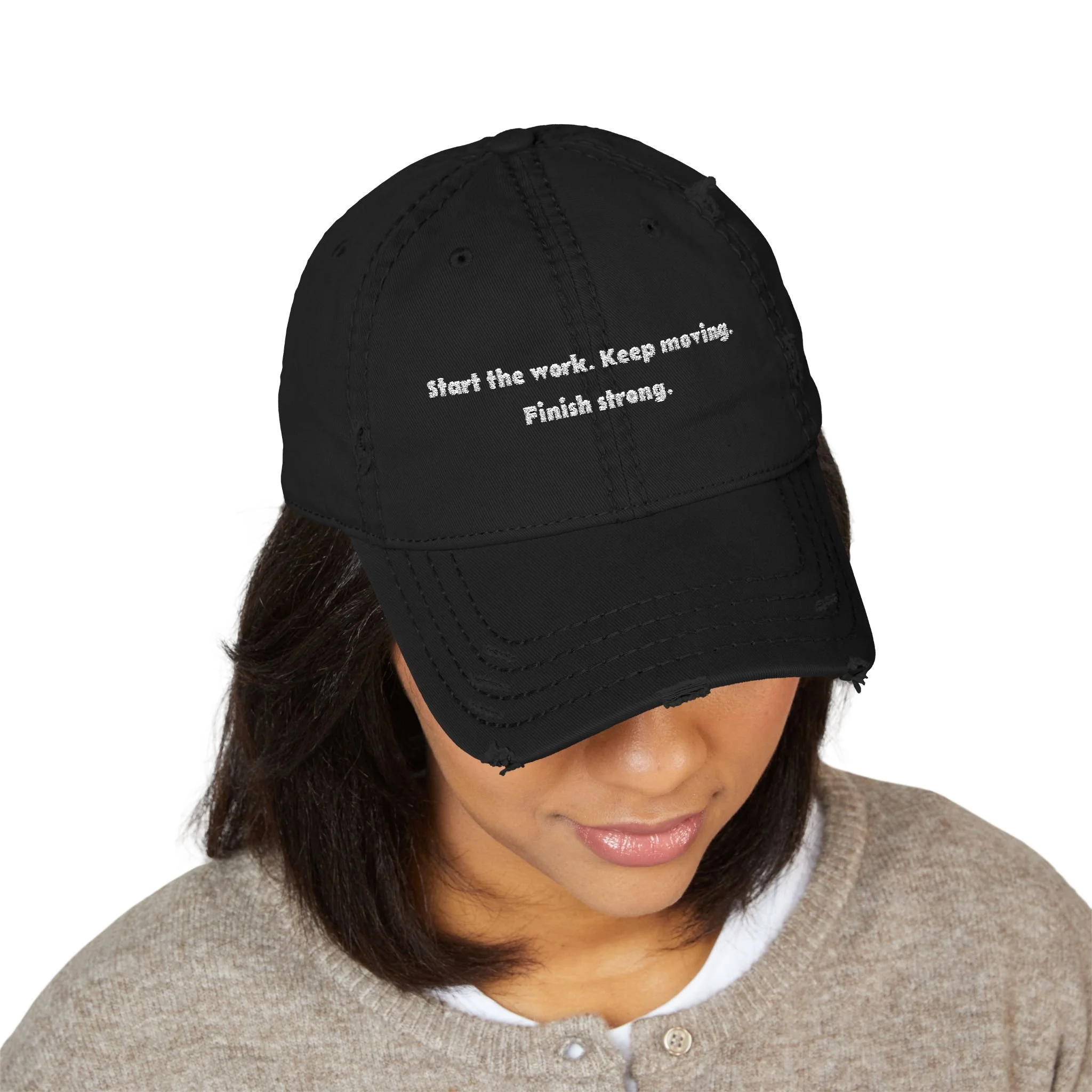Lifestyle front view of person wearing distressed dad hat embroidered with “Start the Work. Keep Moving. Finish Strong.”