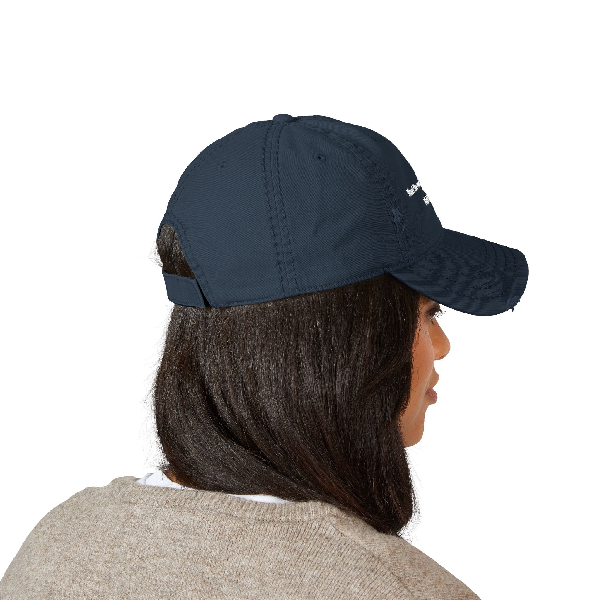 Lifestyle side view of person wearing distressed dad hat with embroidered “Start the Work. Keep Moving. Finish Strong.” message