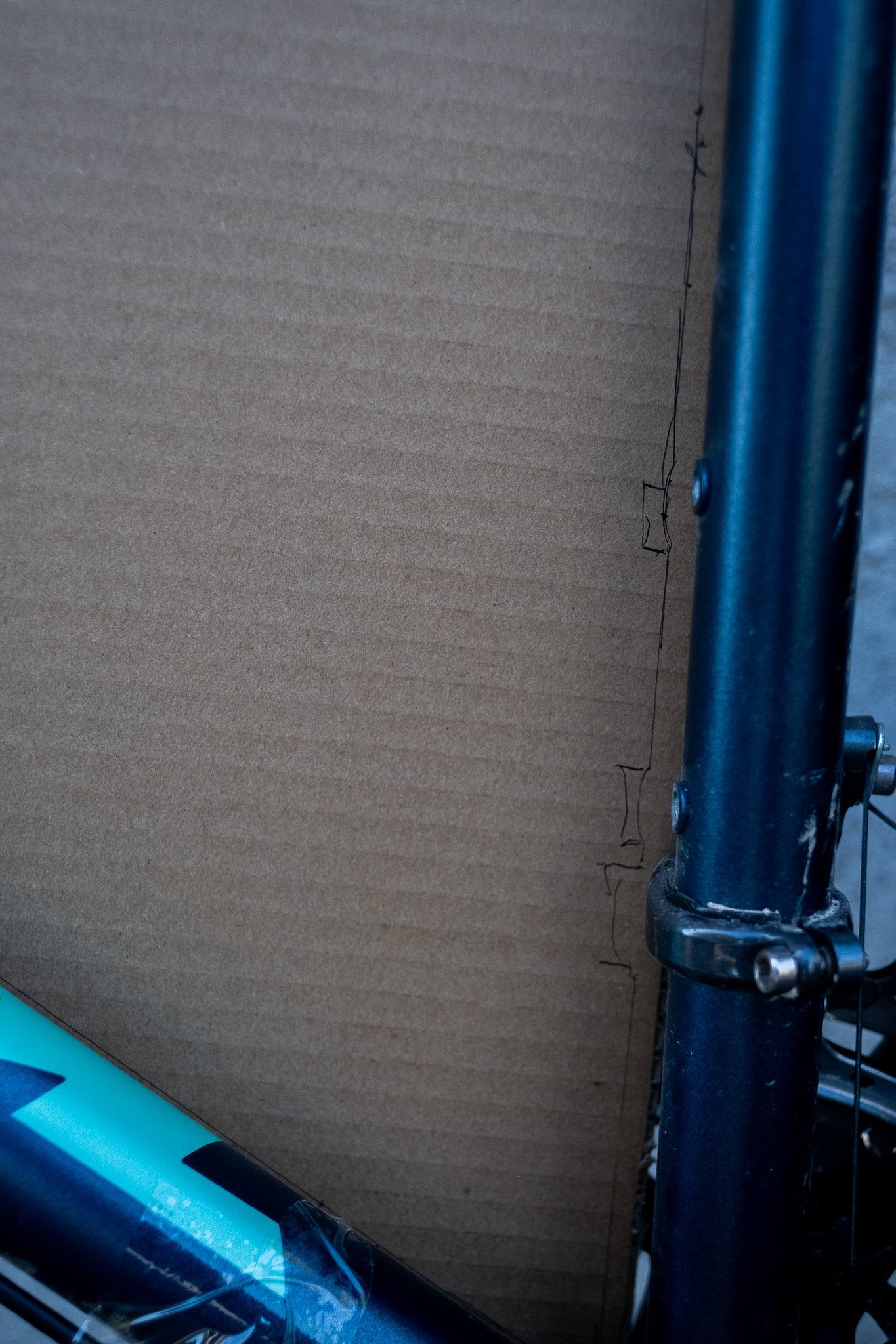 Une grande planche de carton placée verticalement avec une structure métallique à droite.