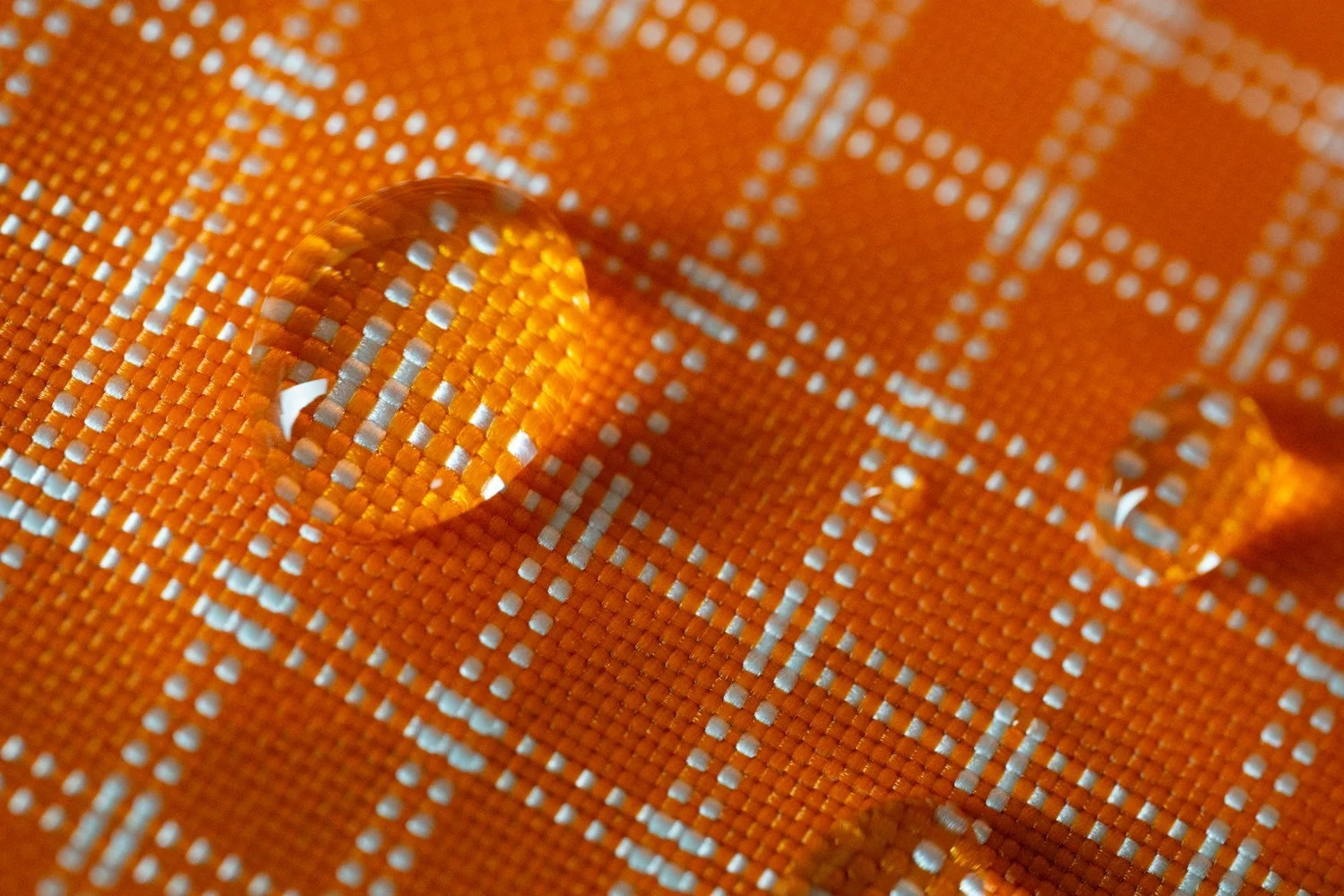 Goutte d'eau sur une toile orange avec motifs en blanc