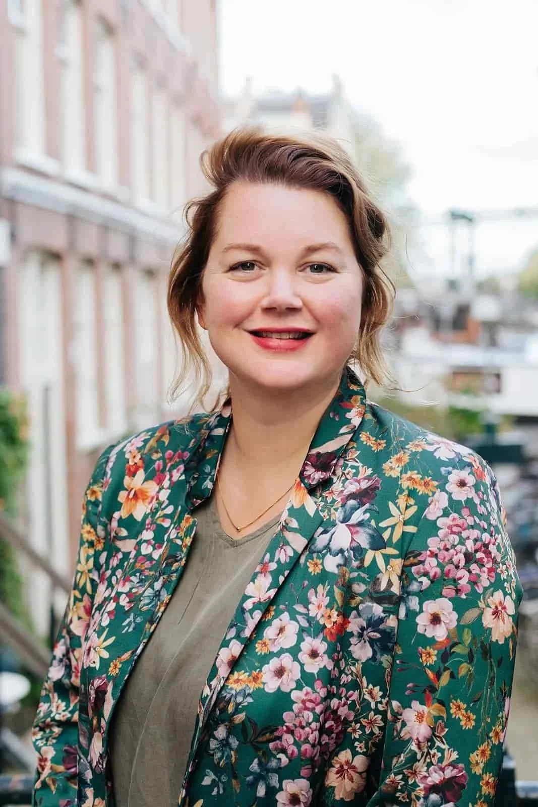 Manon Goudsblom wearing a floral blazer, standing outdoors in an urban setting.