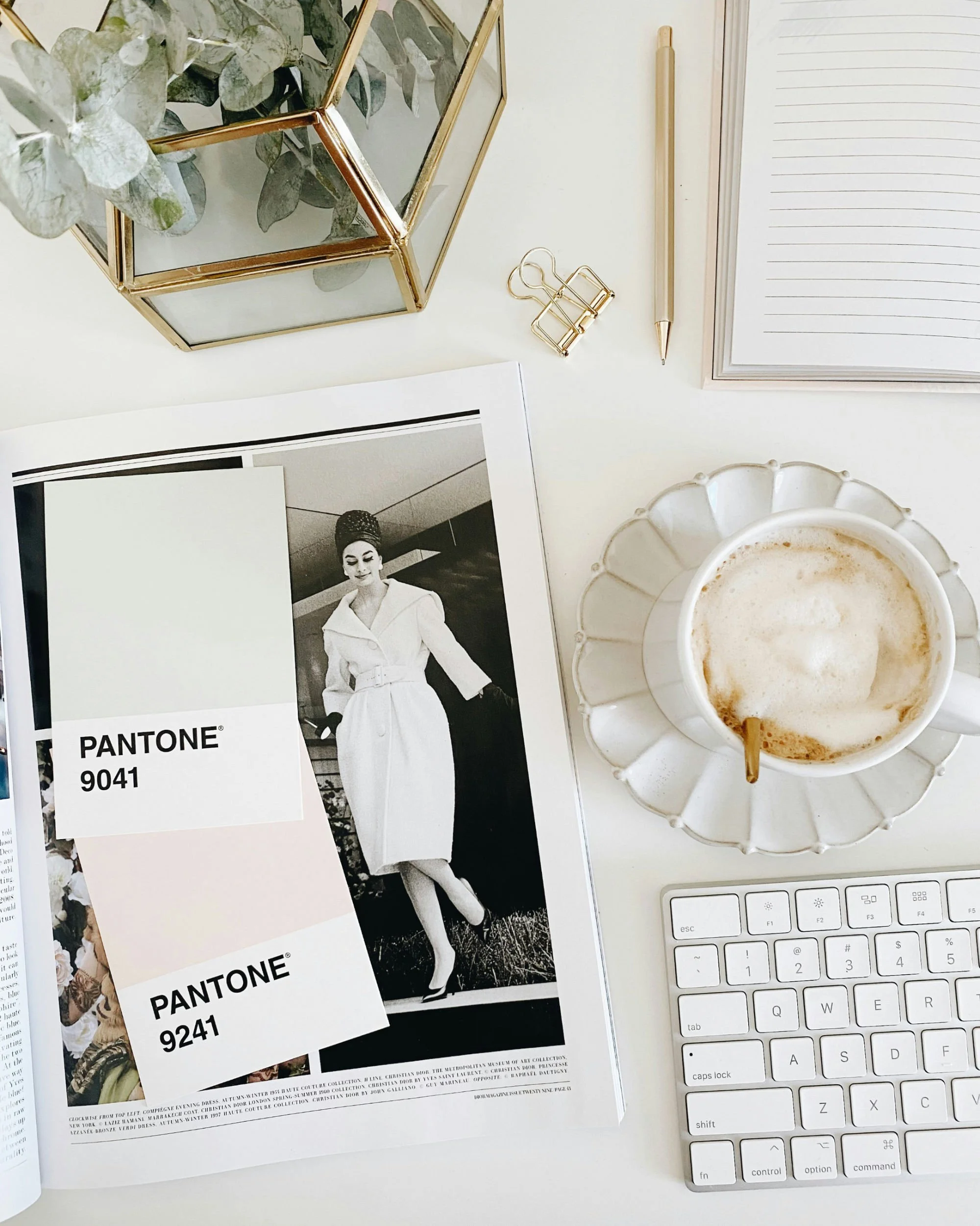 Open magazine with selection of neutral pantone swatches and a keyboard
