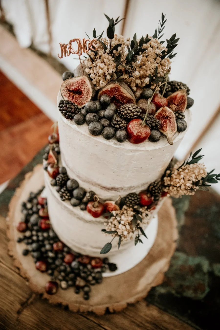 Two tier semi naked cake with fresh red berries and figs