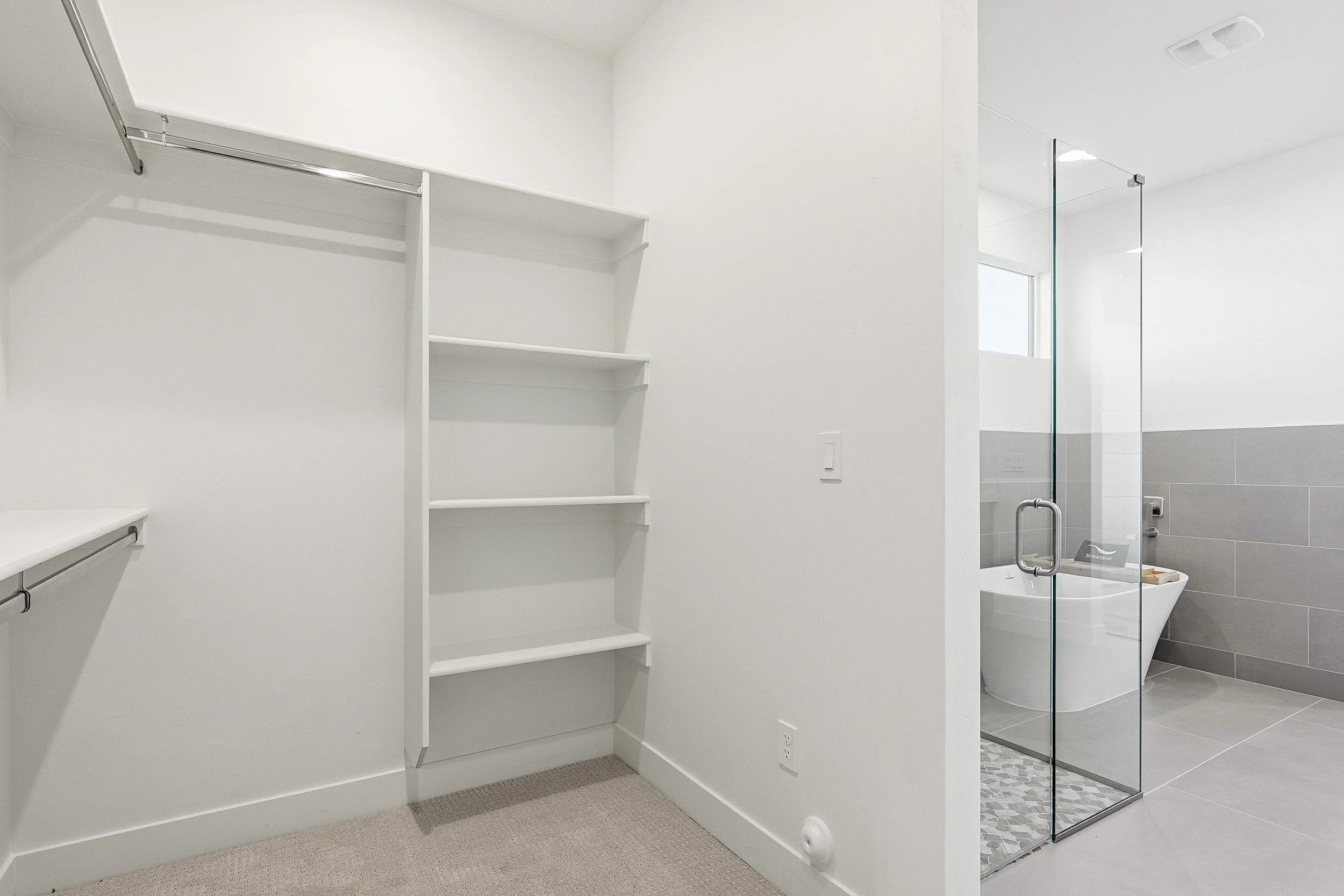 Organized walk-in closet with shelves, drawers, hanging clothes, shoes, and storage baskets