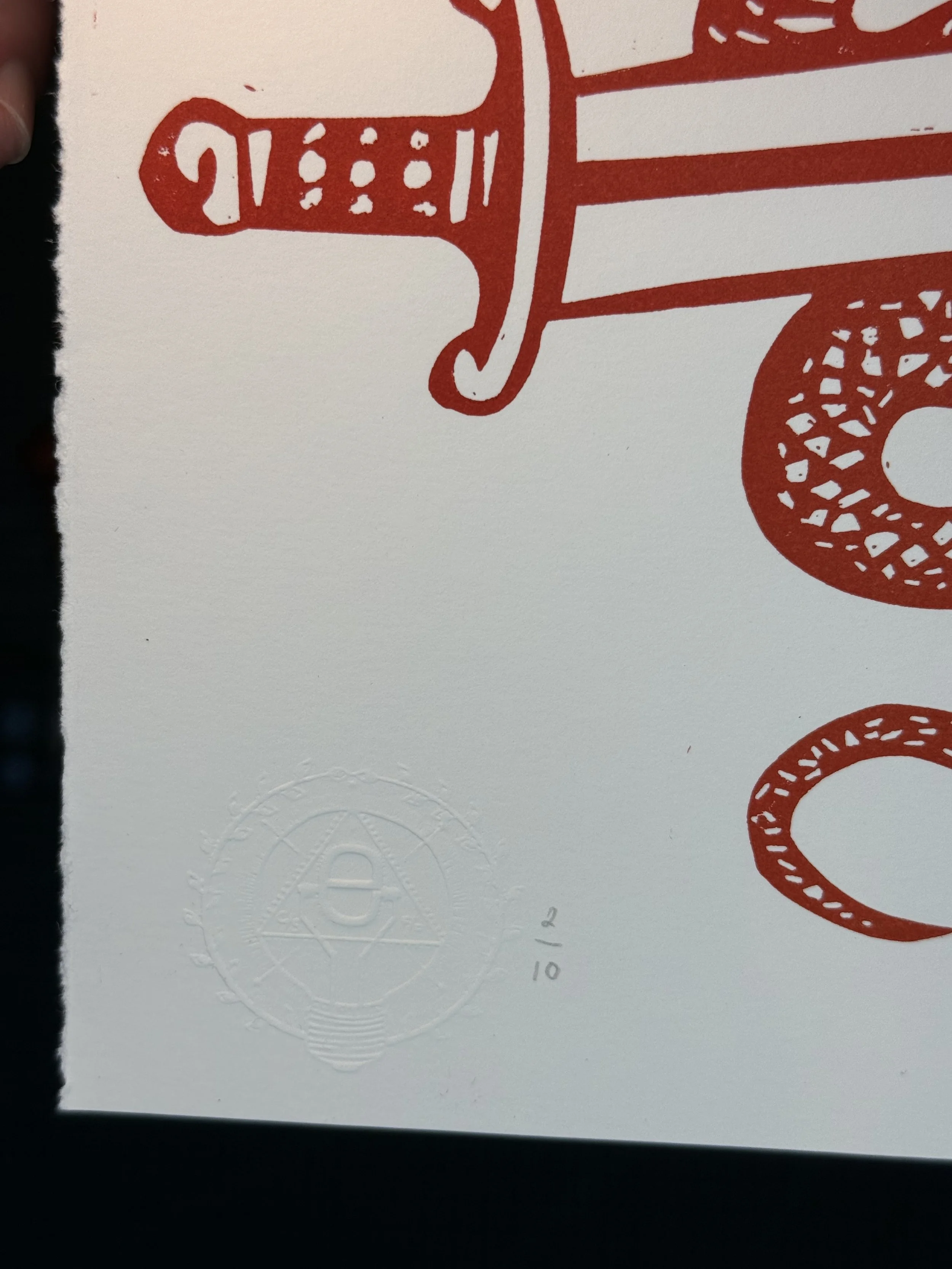 Hand printed linocut showing snake entwined with historic Essex three seaxes emblem