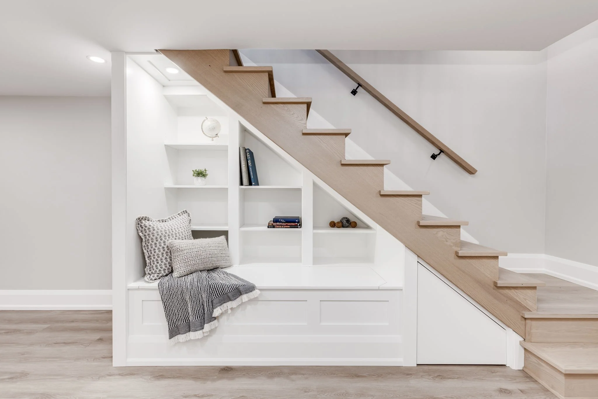 Detail of built-in bench storage under the stairs in an Etobicoke home addition.