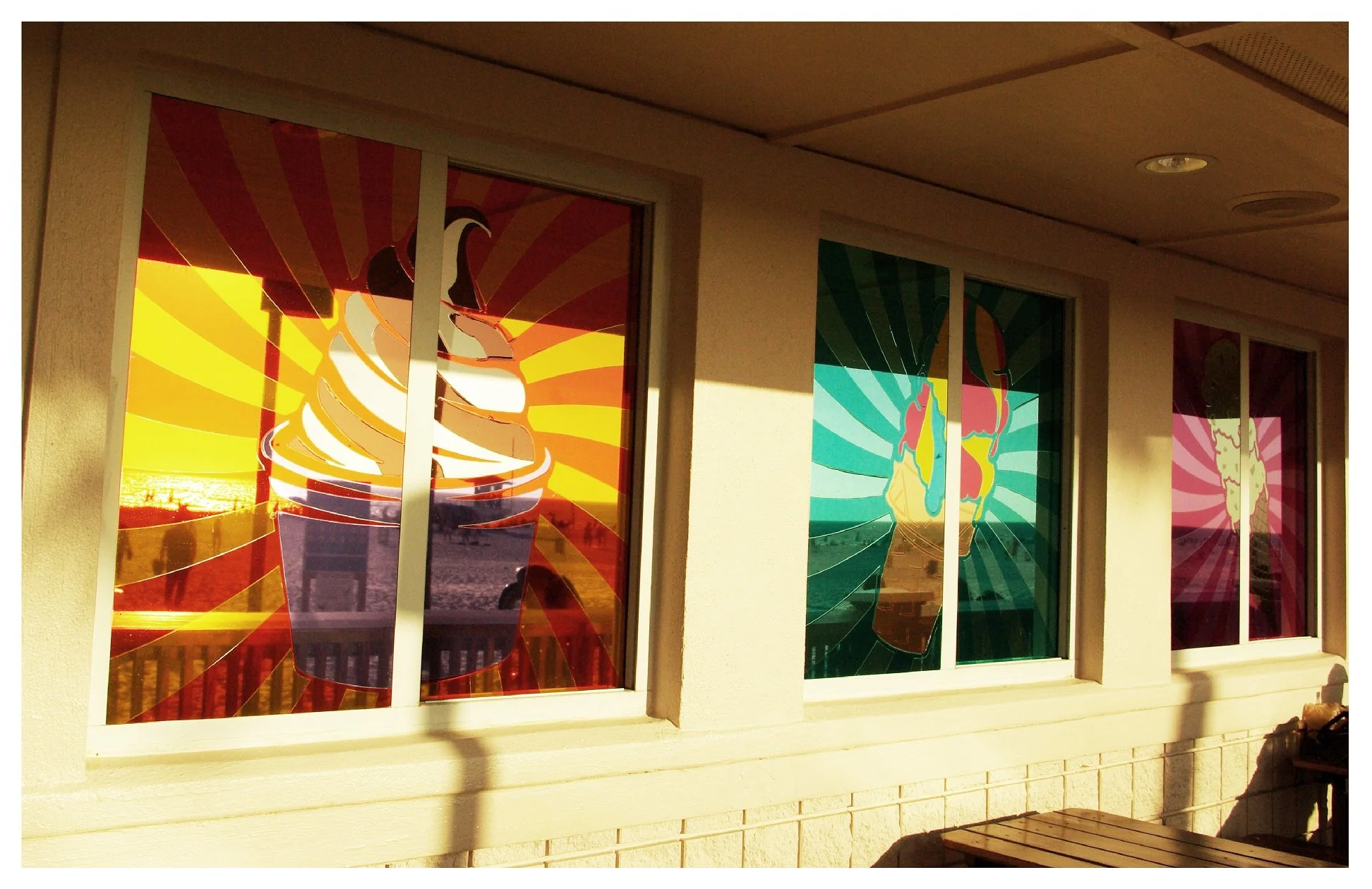 colorful ice cream drawings on windows with sunset reflection colored window film