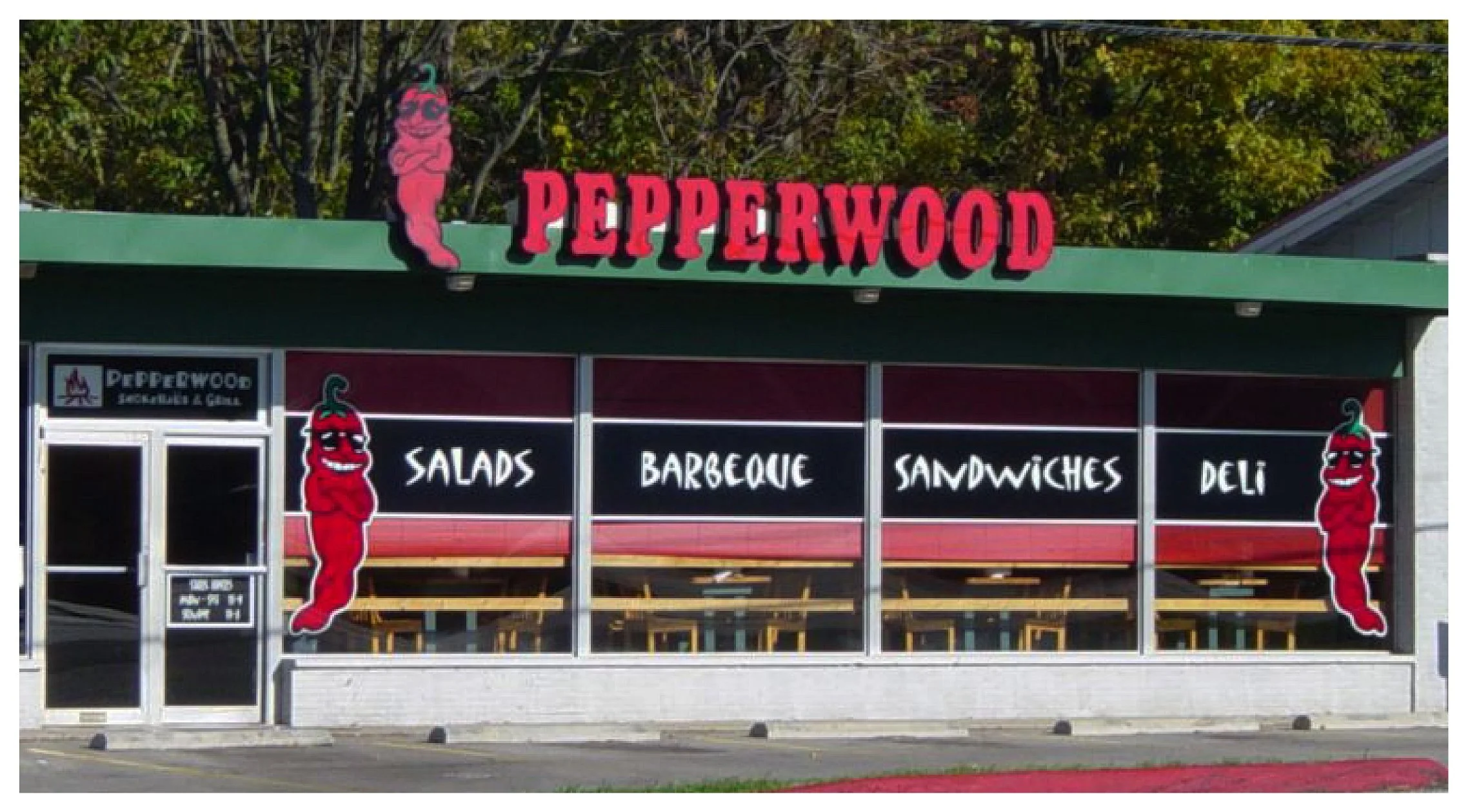Exterior of Pepperwood restaurant featuring signage for salads, barbeque, sandwiches, and deli with chili pepper graphics. colored window film
