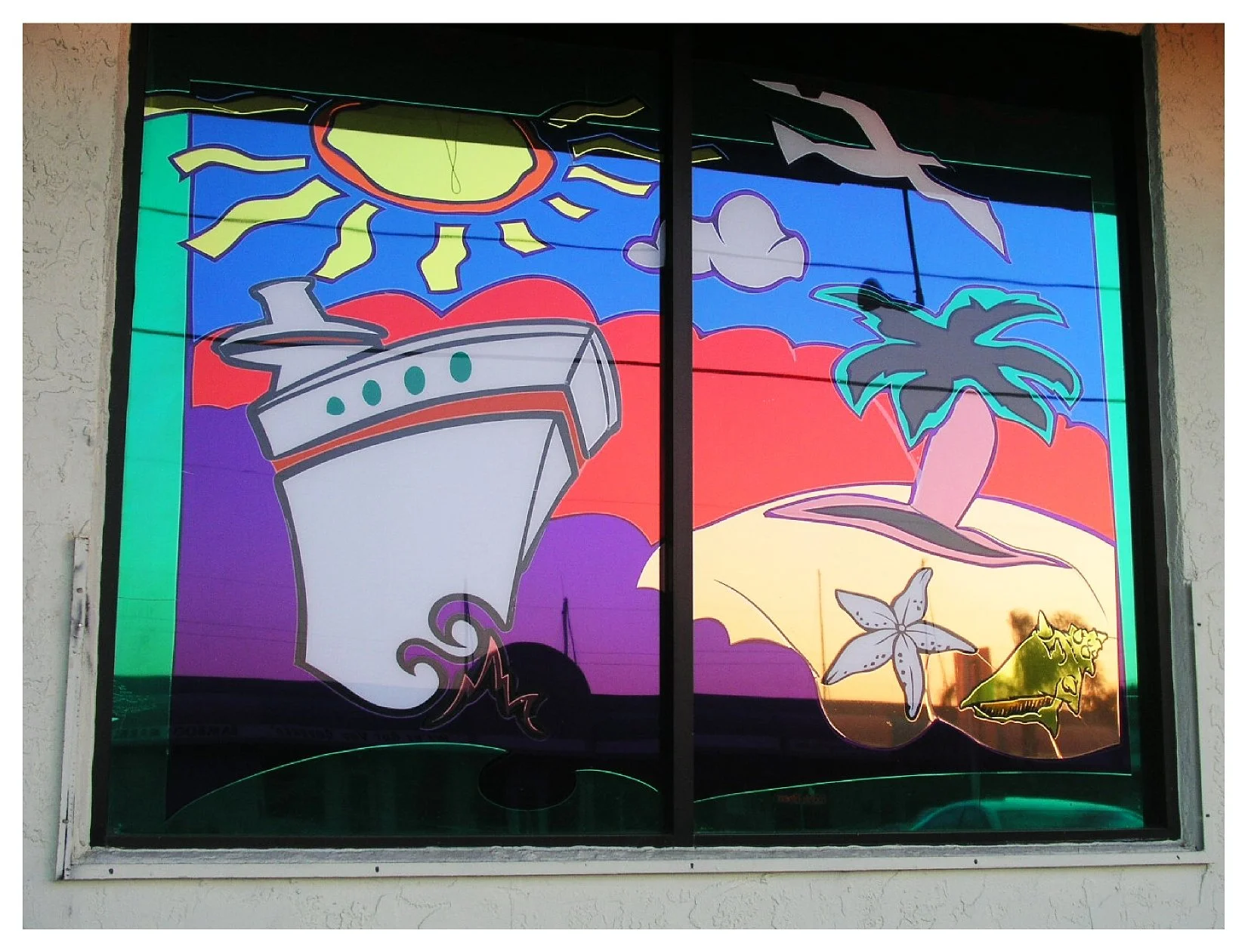 Colorful mural on window featuring a cruise ship, sun, seagull, clouds, palm tree, starfish, and seashell. colored window film