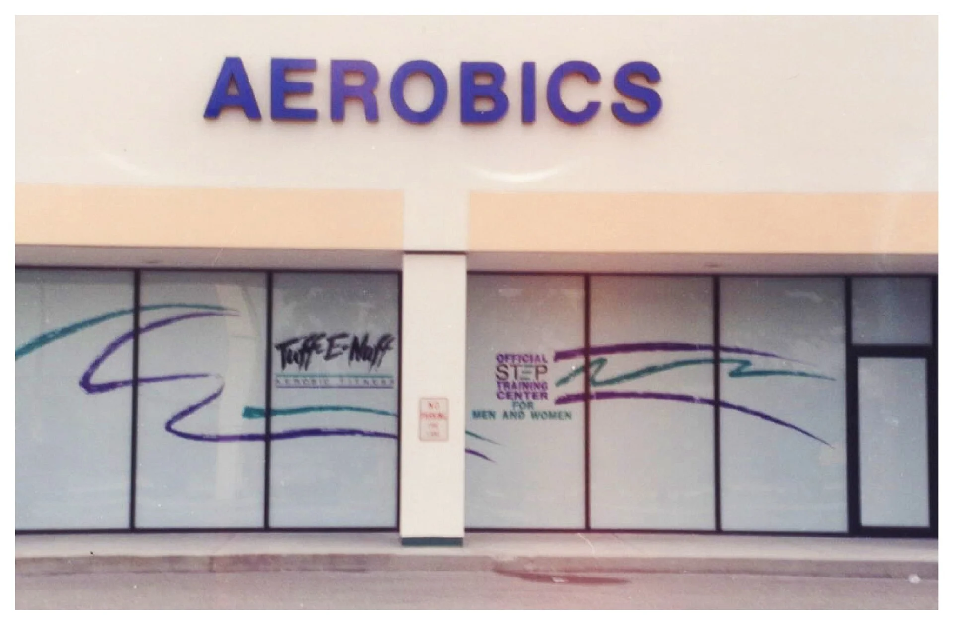 Storefront with 'AEROBICS' sign and window graphics colored window film