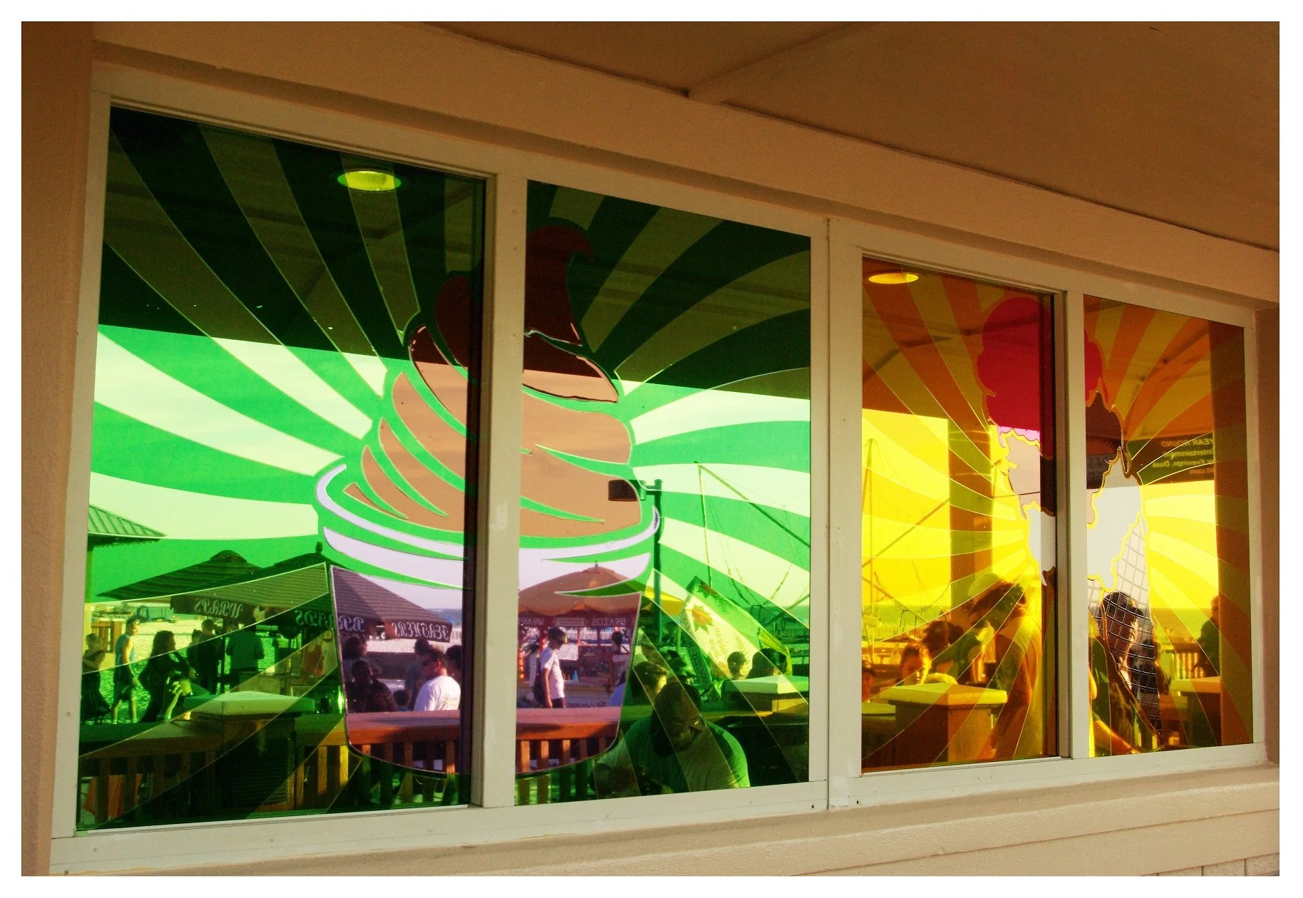 Colorful reflections in ice cream shop window with large ice cream graphic. colored window film