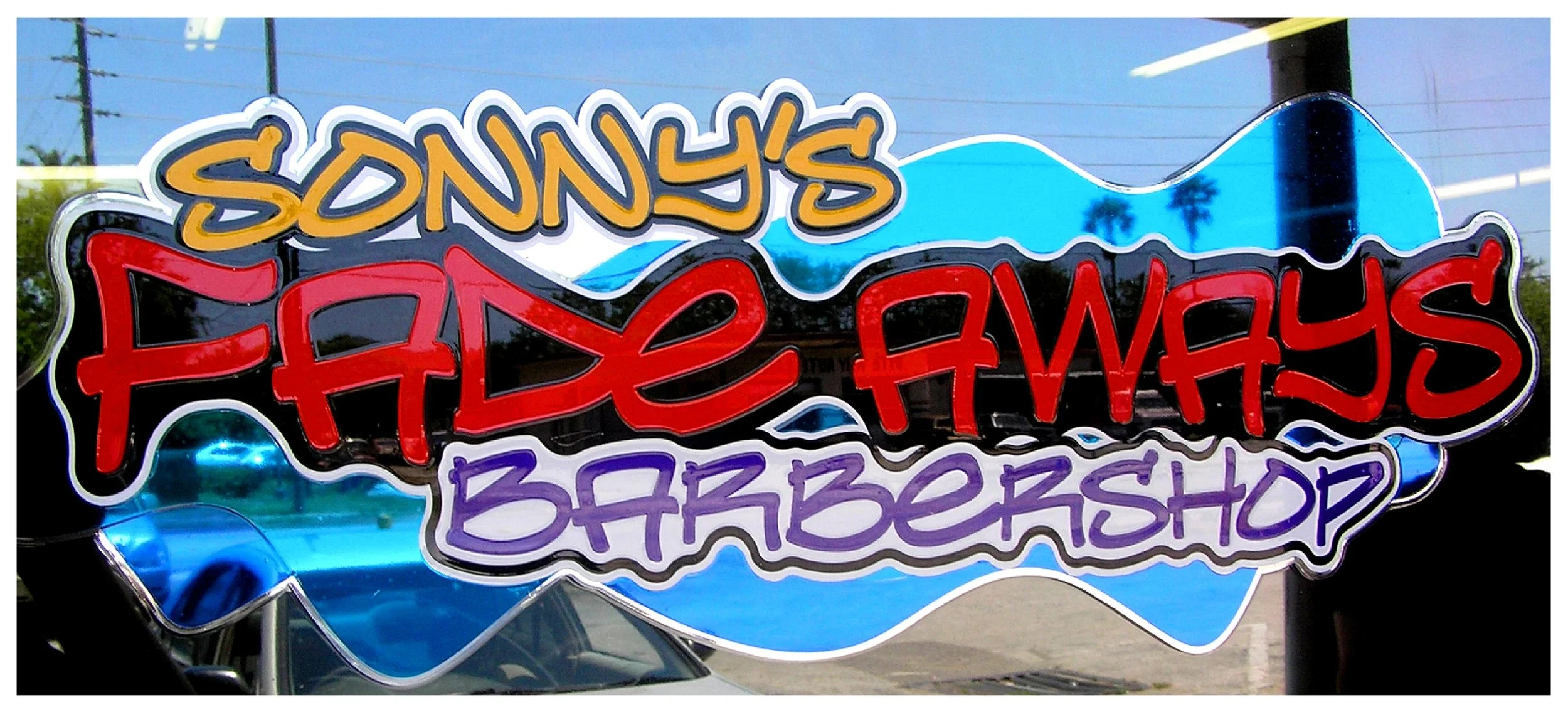 "Sonny's Fade Aways Barbershop" window sign with colorful text. colored window film