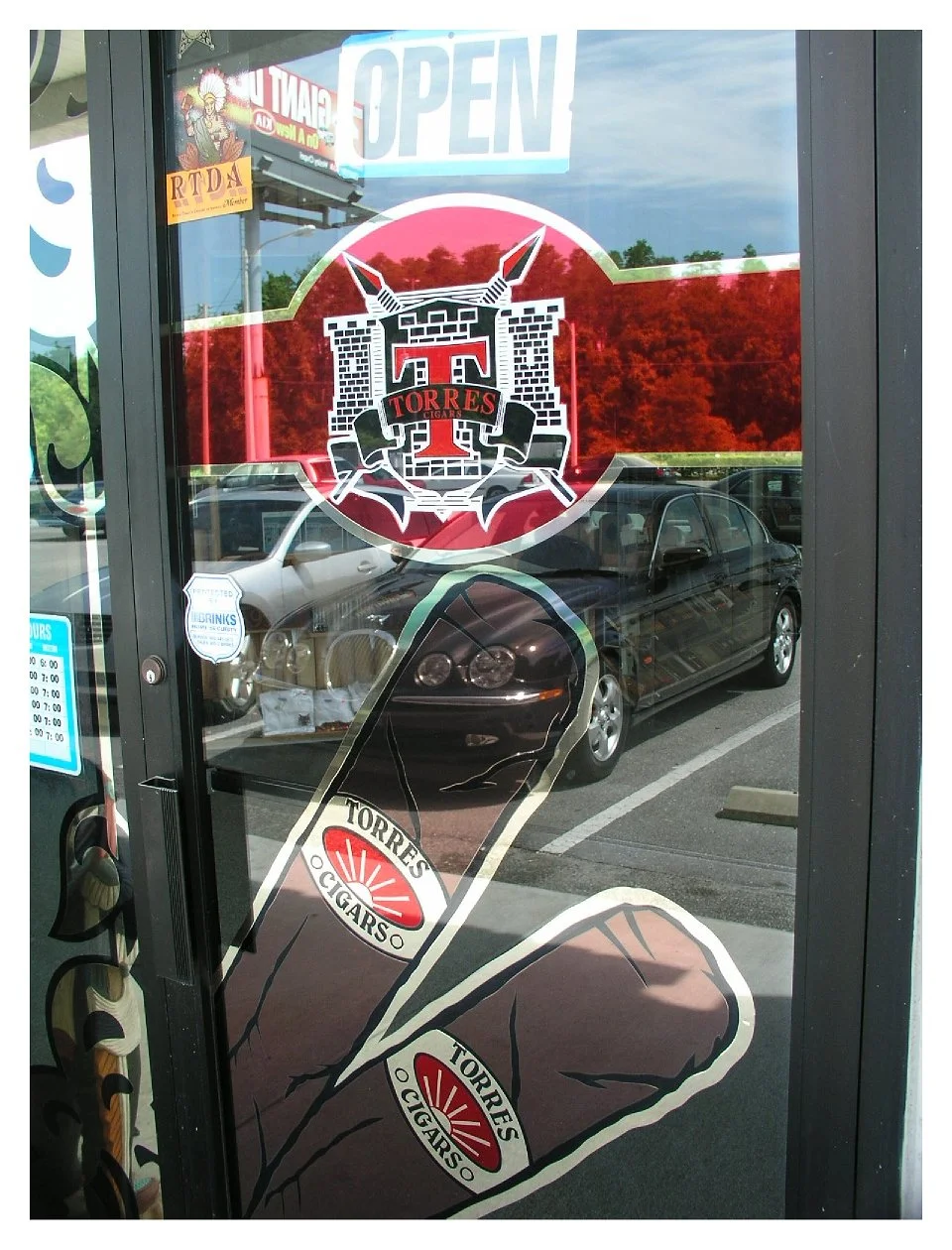 storefront door with Torres Cigars logo and decal of cigars colored window film