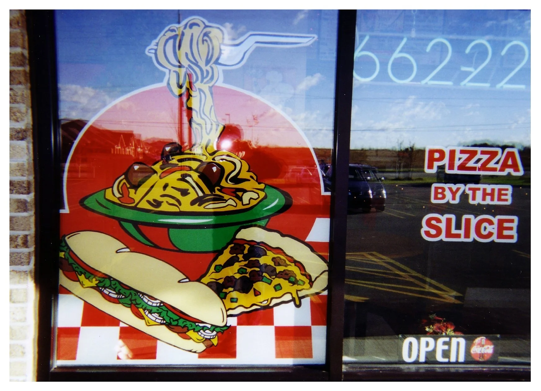 Window sign showing pasta, sandwich, and pizza slice with text "Pizza by the Slice" and "Open." colored window film
