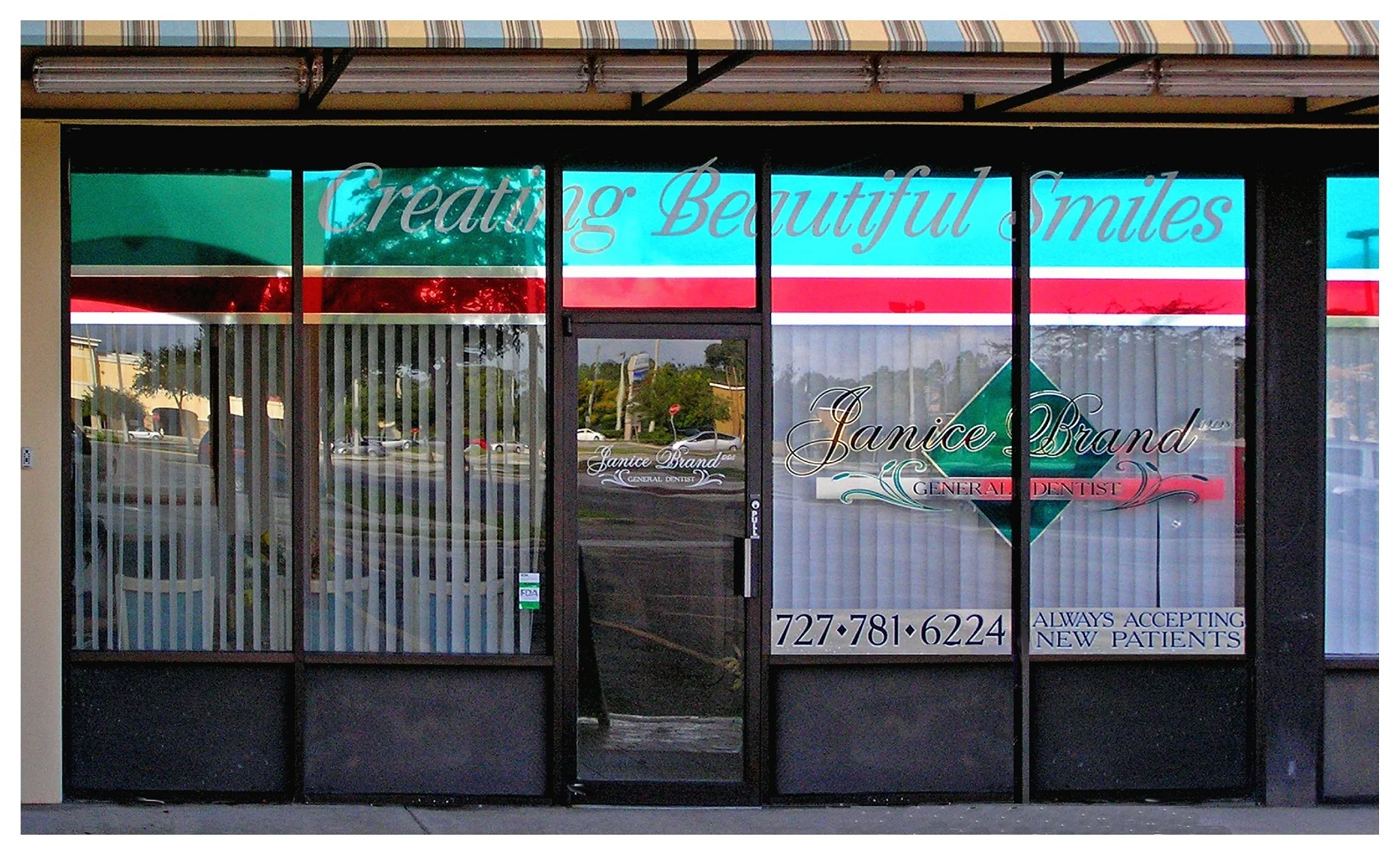 Dental office storefront with signage for "Creating Beautiful Smiles" and "General Dentist," displaying contact number and "Always Accepting New Patients." colored window film